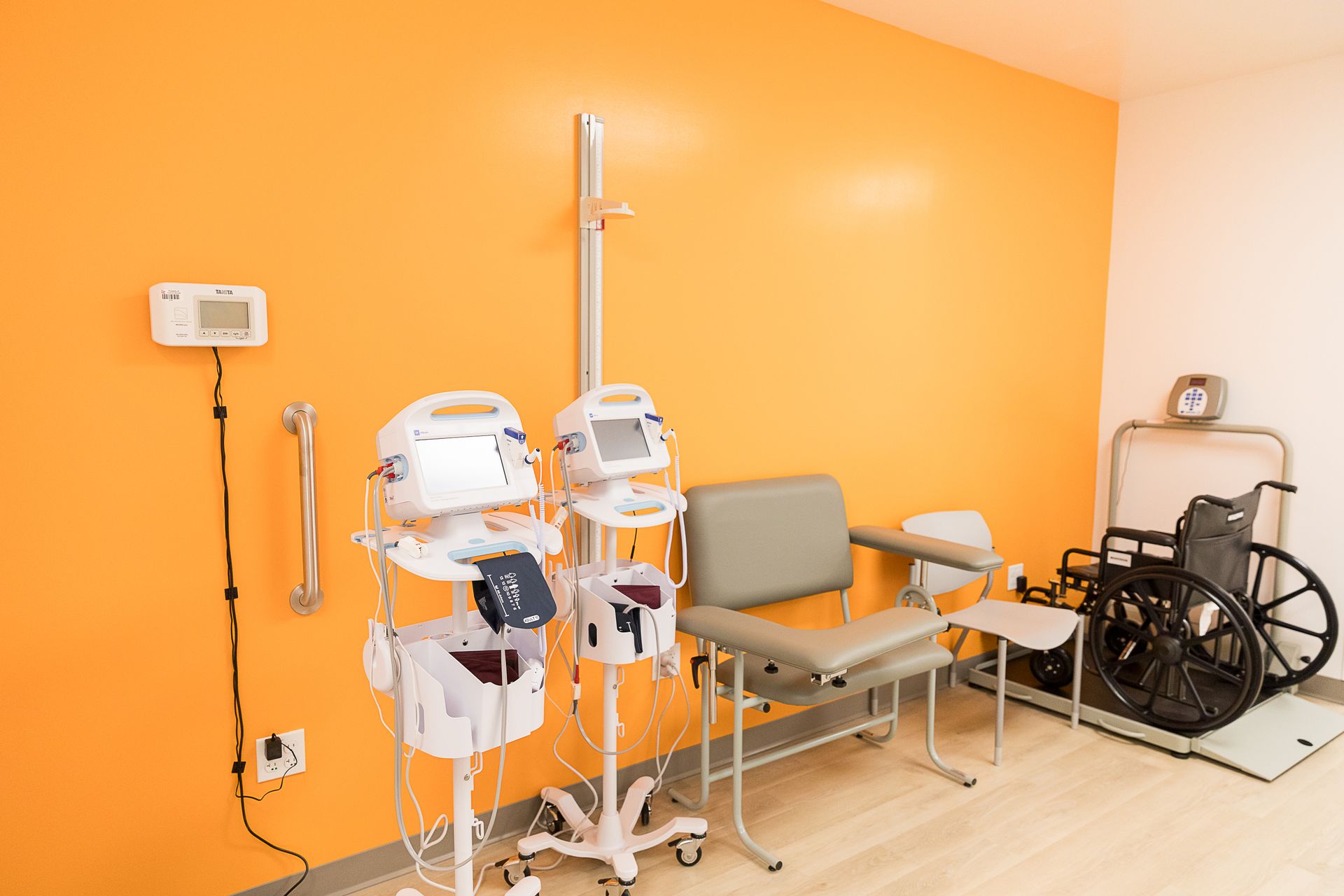 A waiting room with chairs , a wheelchair , and medical equipment.