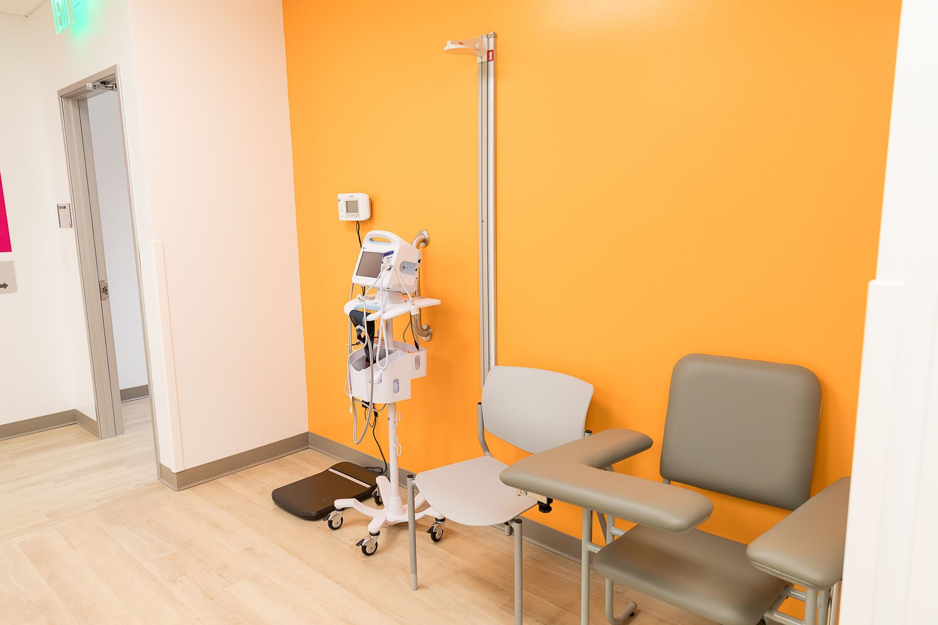 A waiting room in a hospital with a chair and a table.