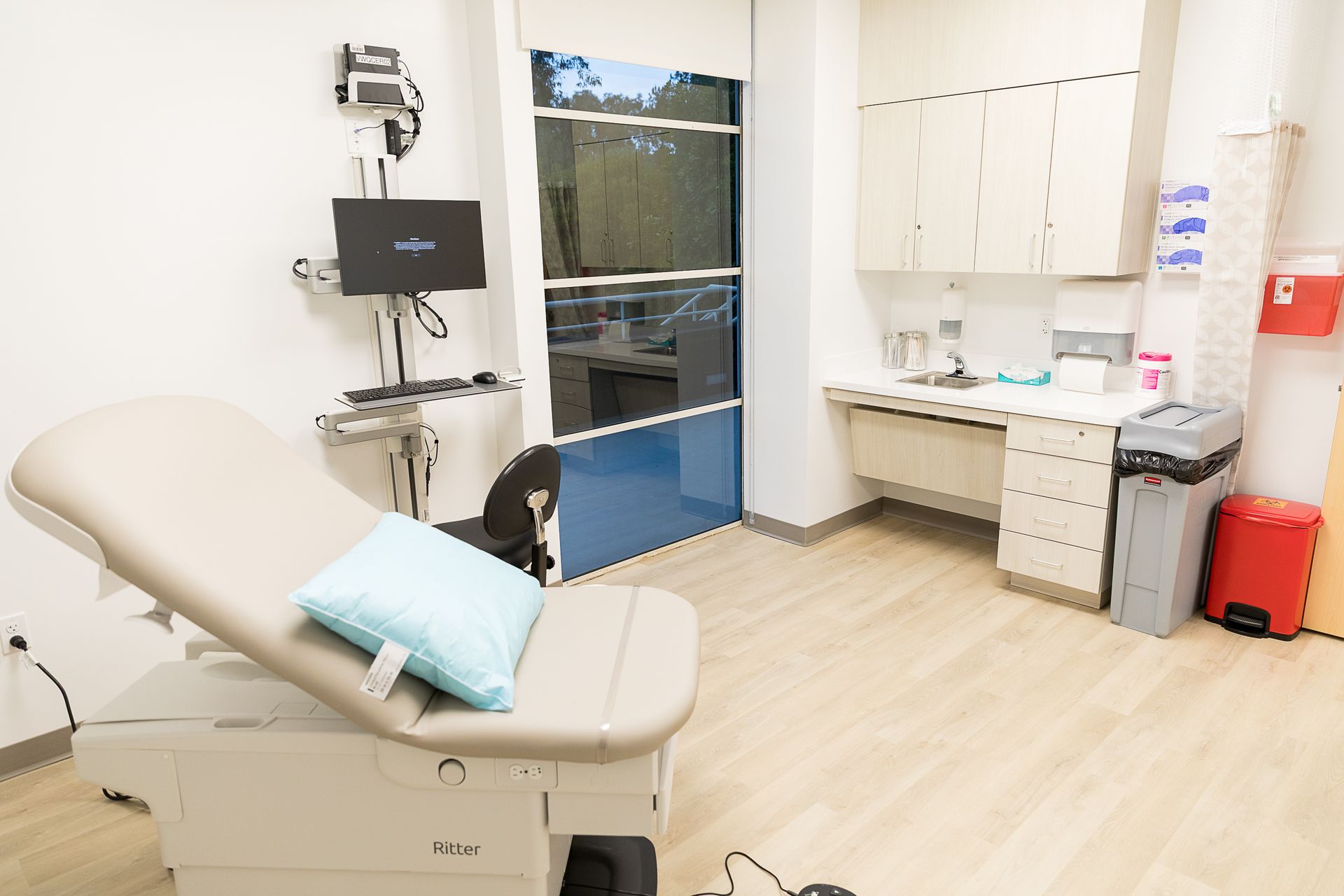 A doctor 's office with a couch and a monitor.