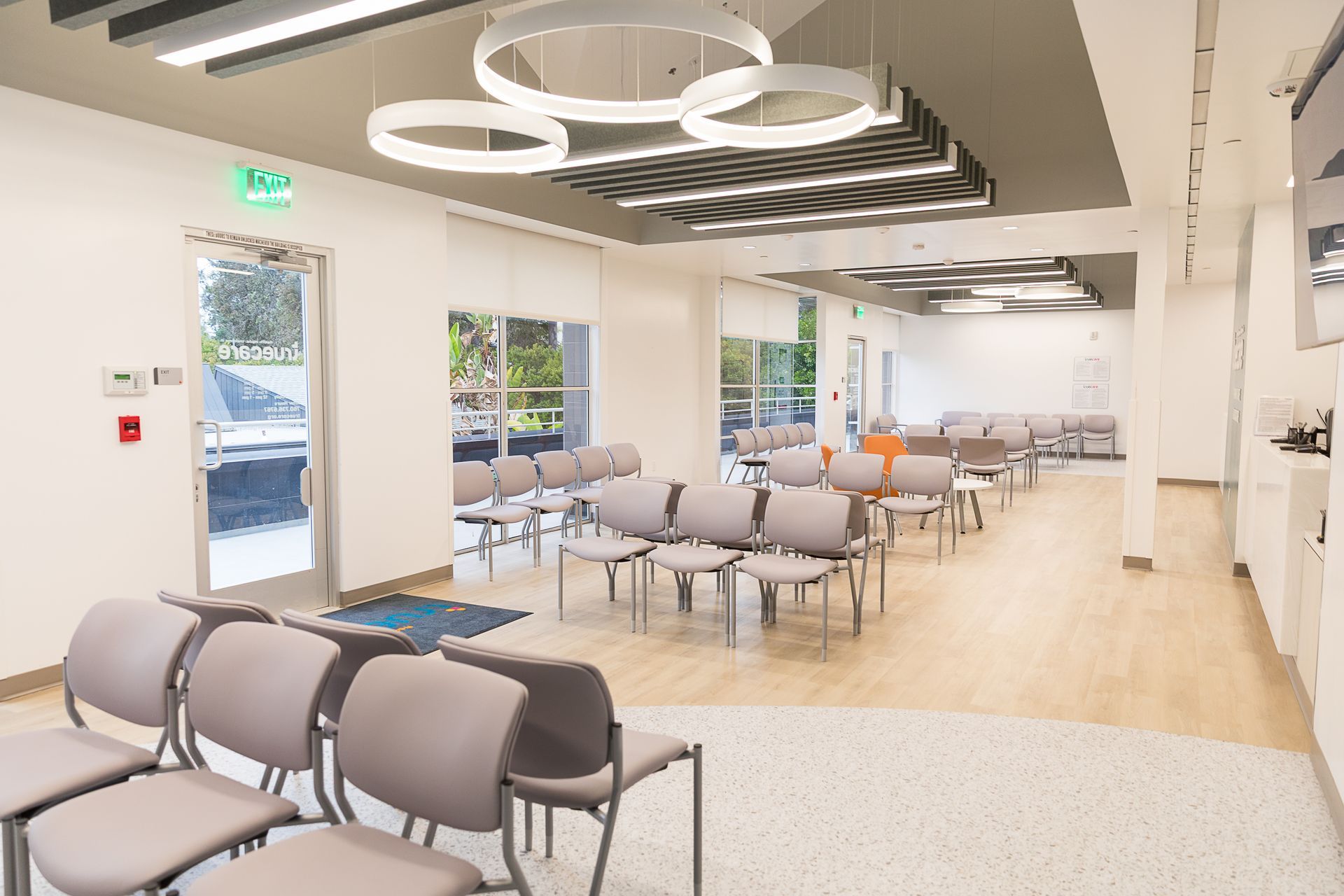 There are a lot of chairs in the waiting room of a hospital.