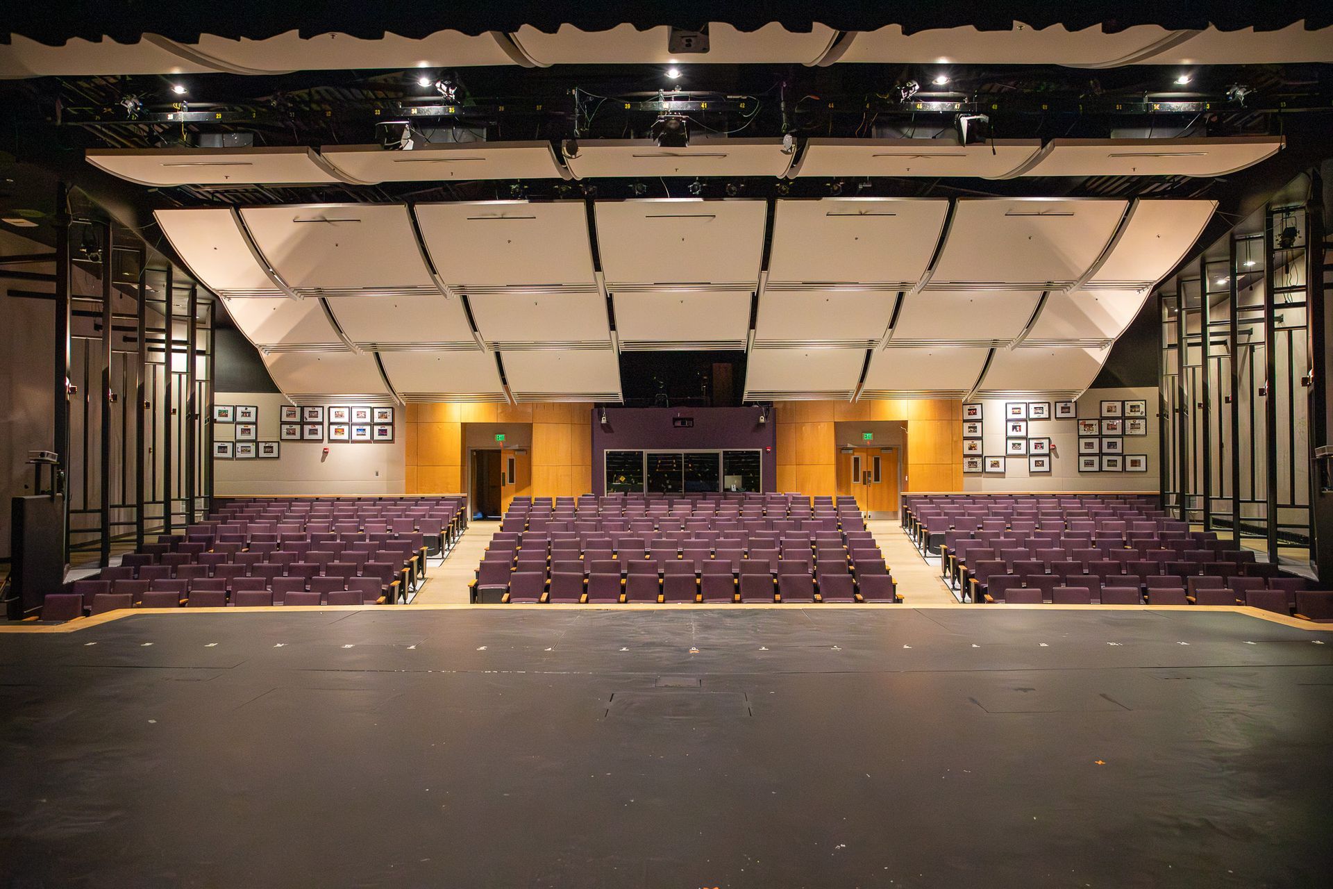 Empty theater auditorium with rows of purple seats and a stage at the back
