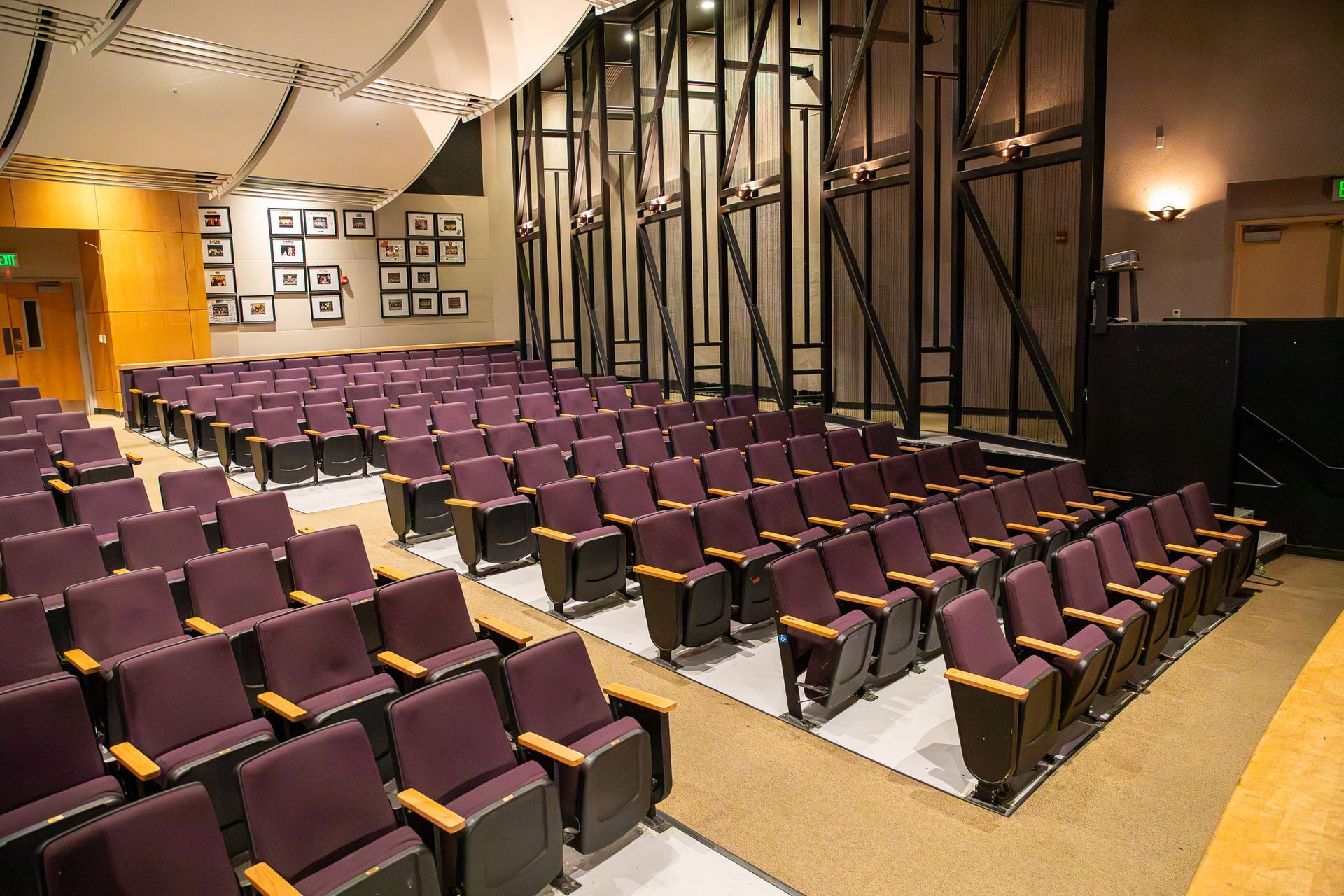 Empty theater with rows of purple seats and a stage area on the right