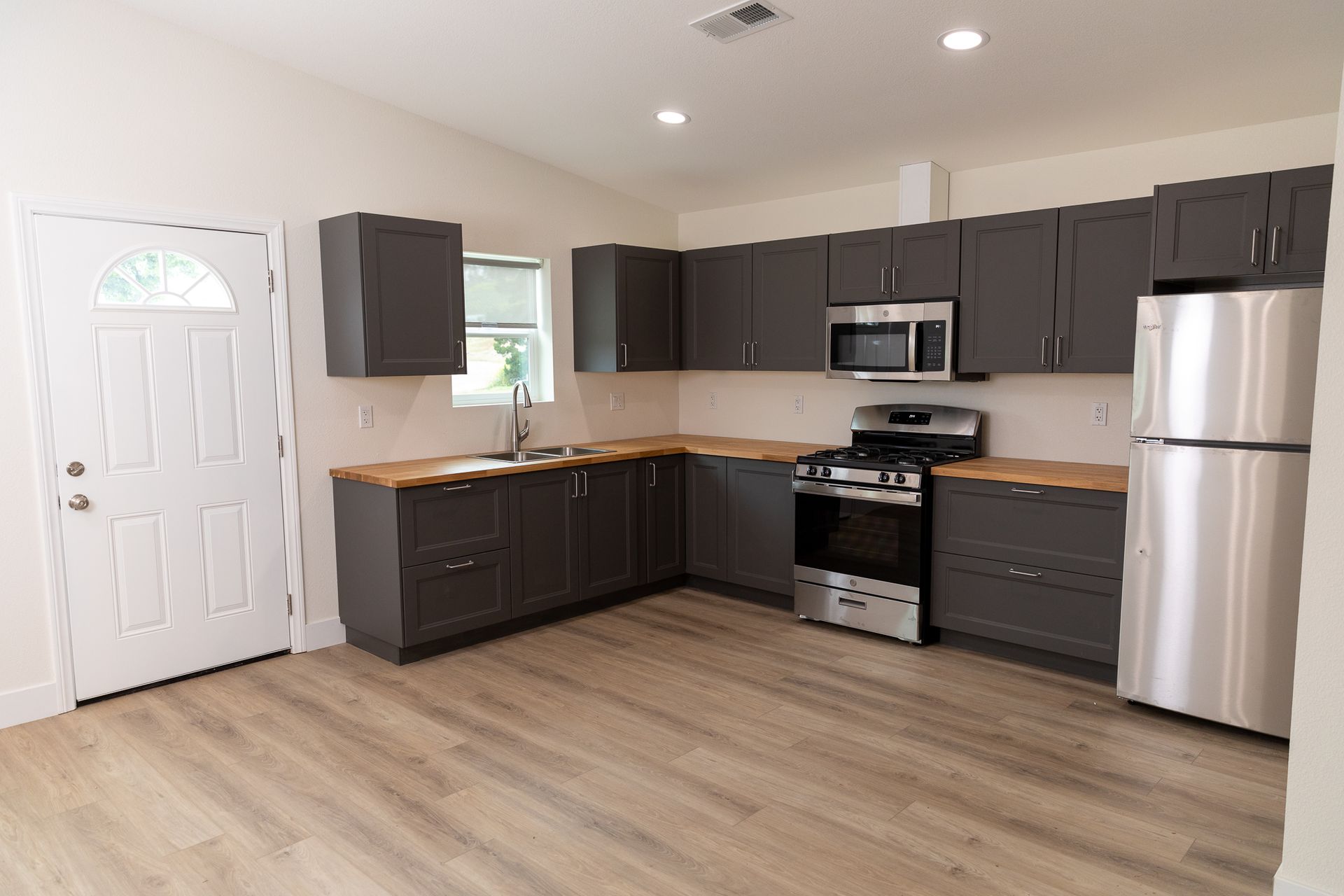 A kitchen with gray cabinets and stainless steel appliances