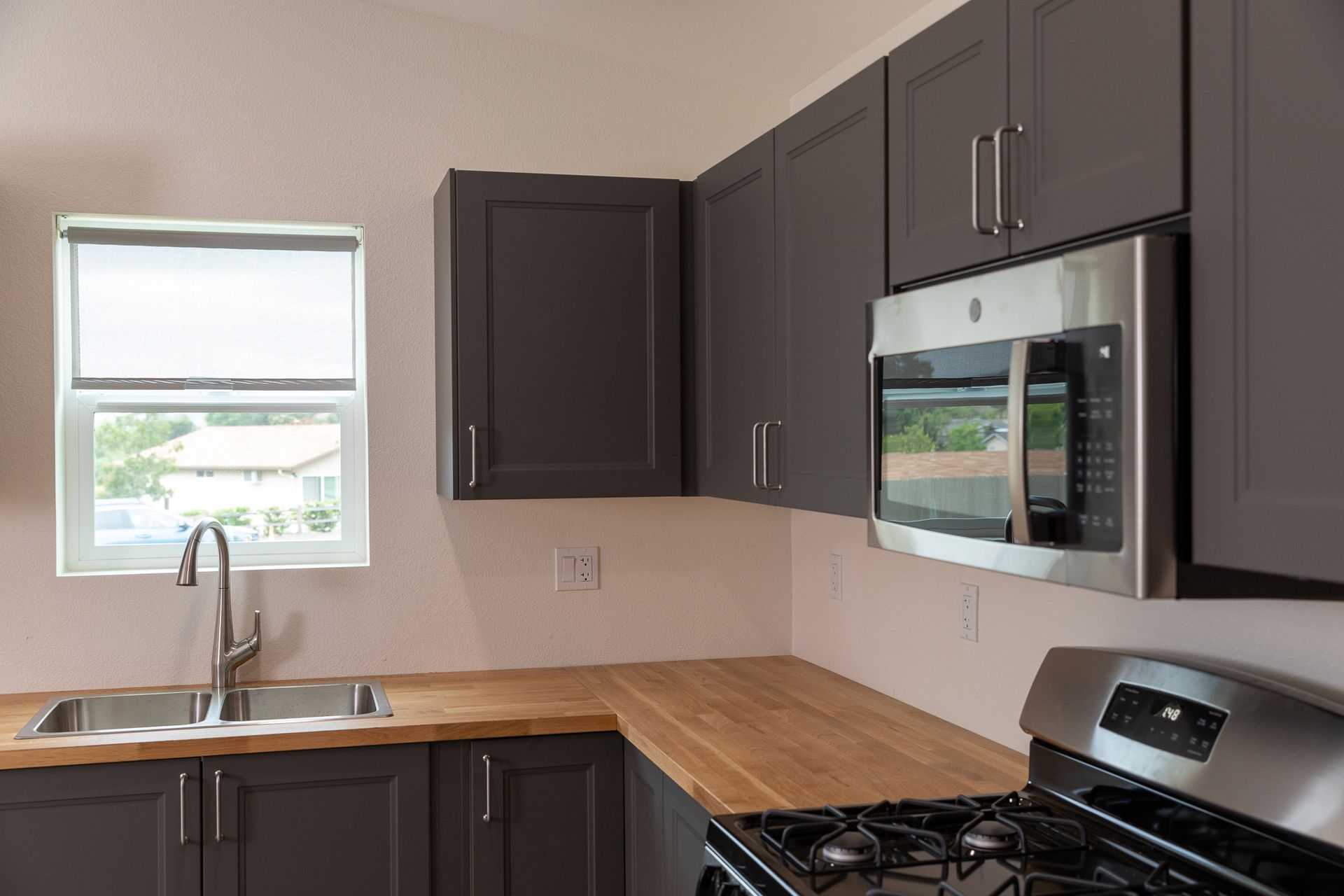 A kitchen with stainless steel appliances and black cabinets