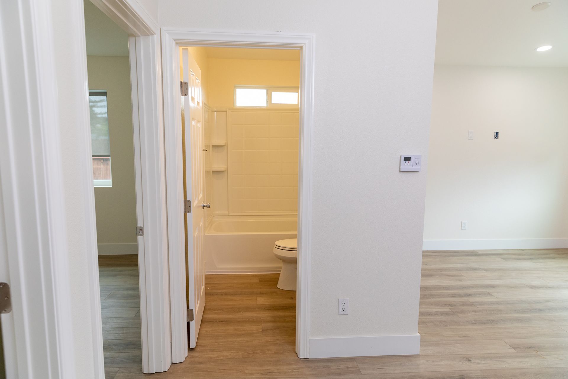 An empty bathroom with a toilet and bathtub