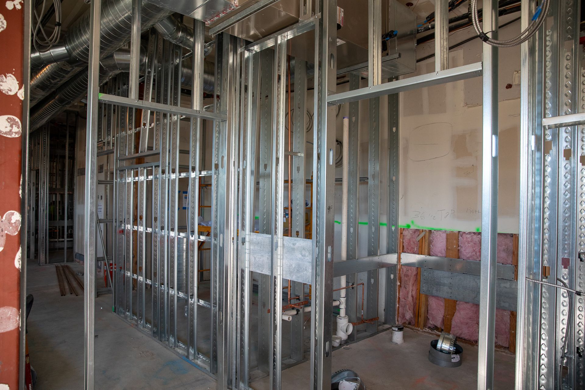 Interior under construction with exposed metal framing and unfinished walls.