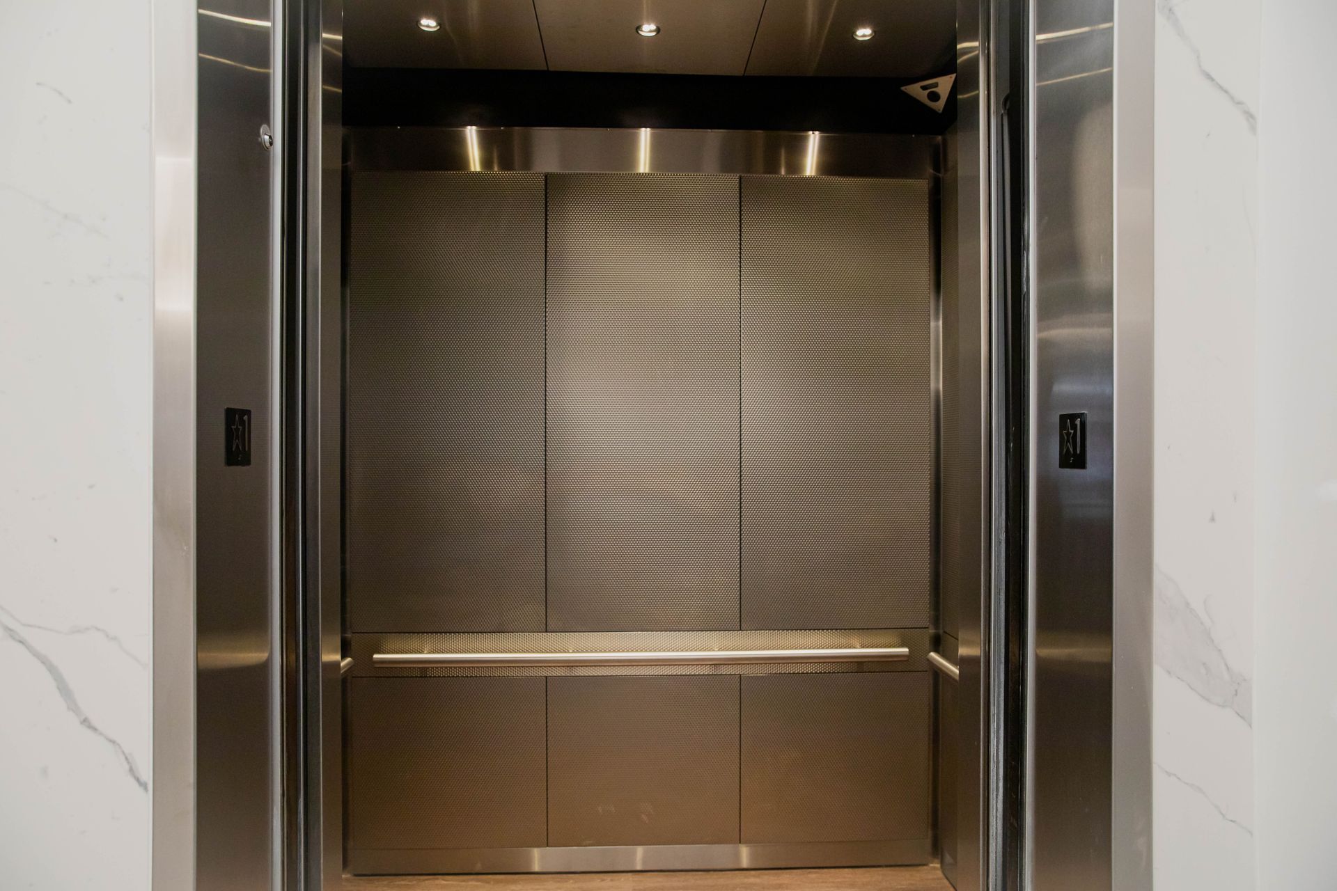 Closed metal elevator doors in a marble hallway