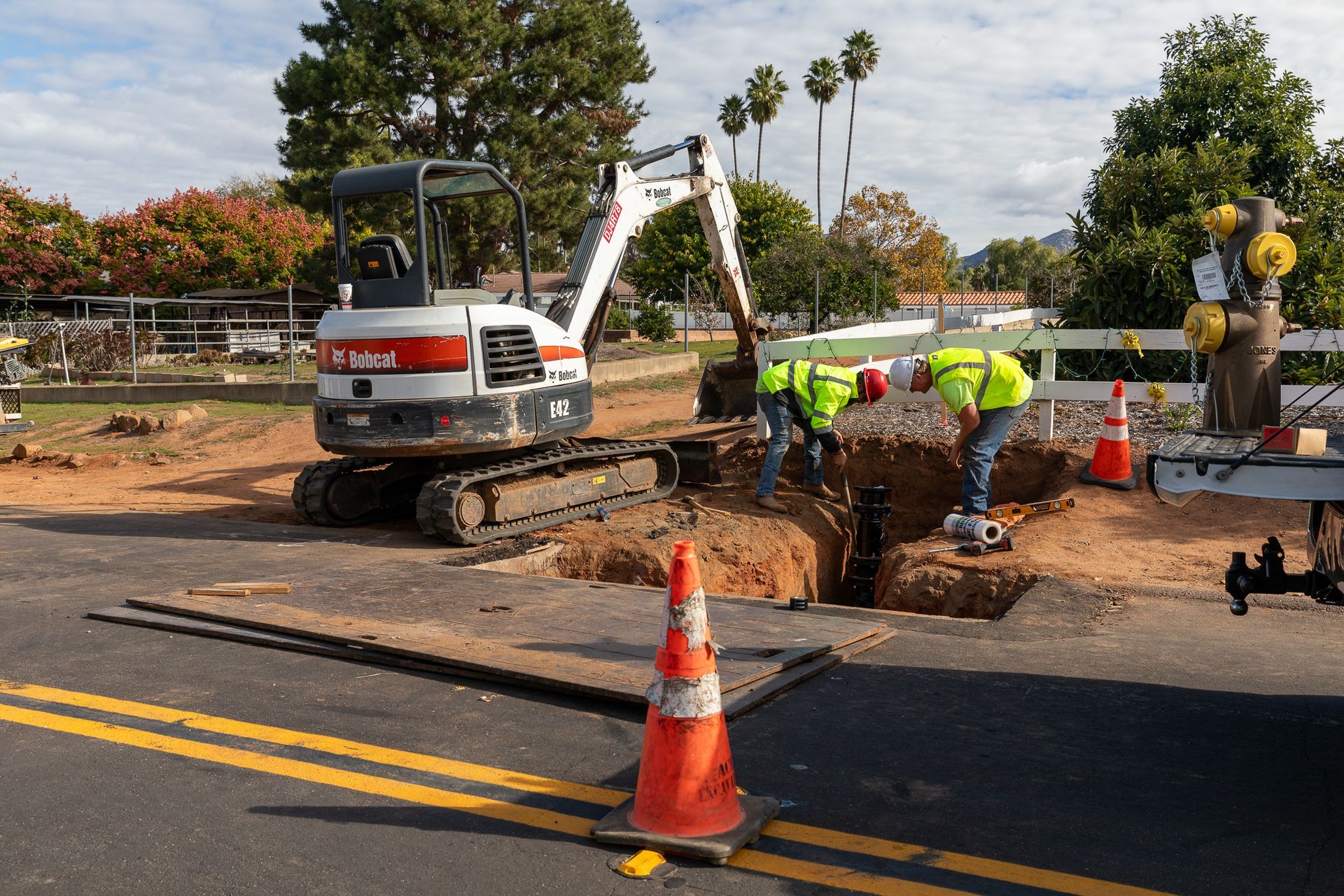 A bobcat excavator is being used to dig a hole in the ground