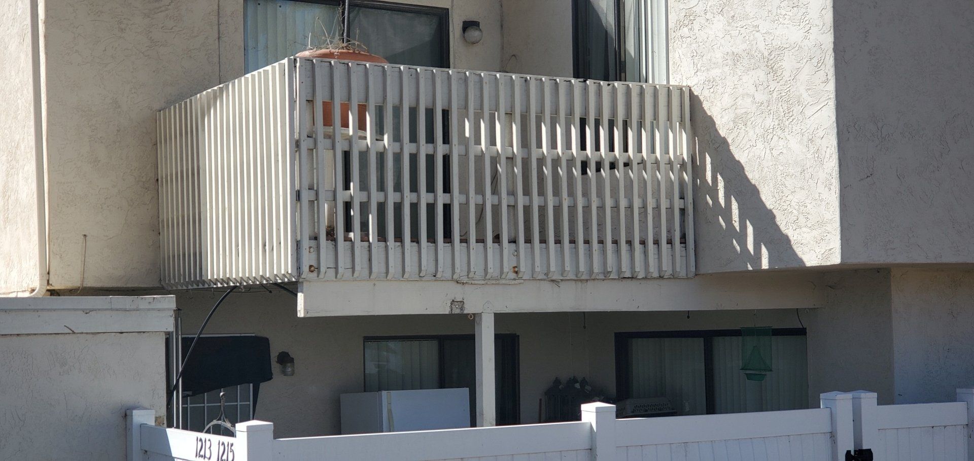 A building with a balcony and a white fence