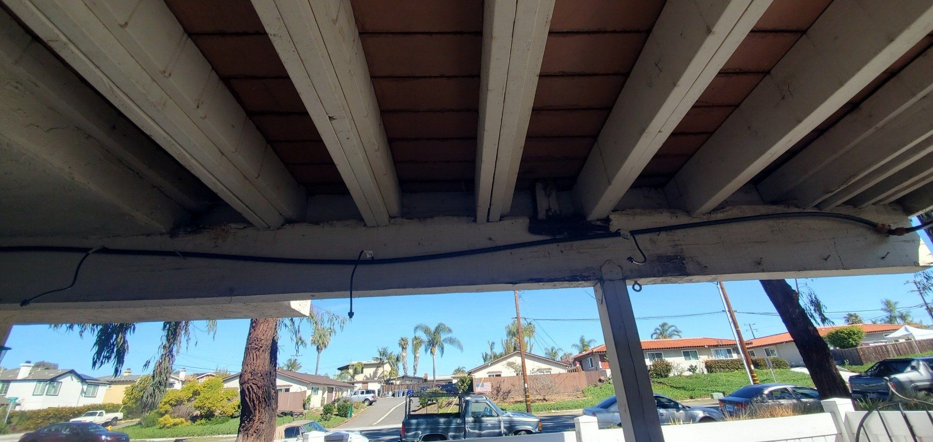 A car is parked underneath a wooden structure