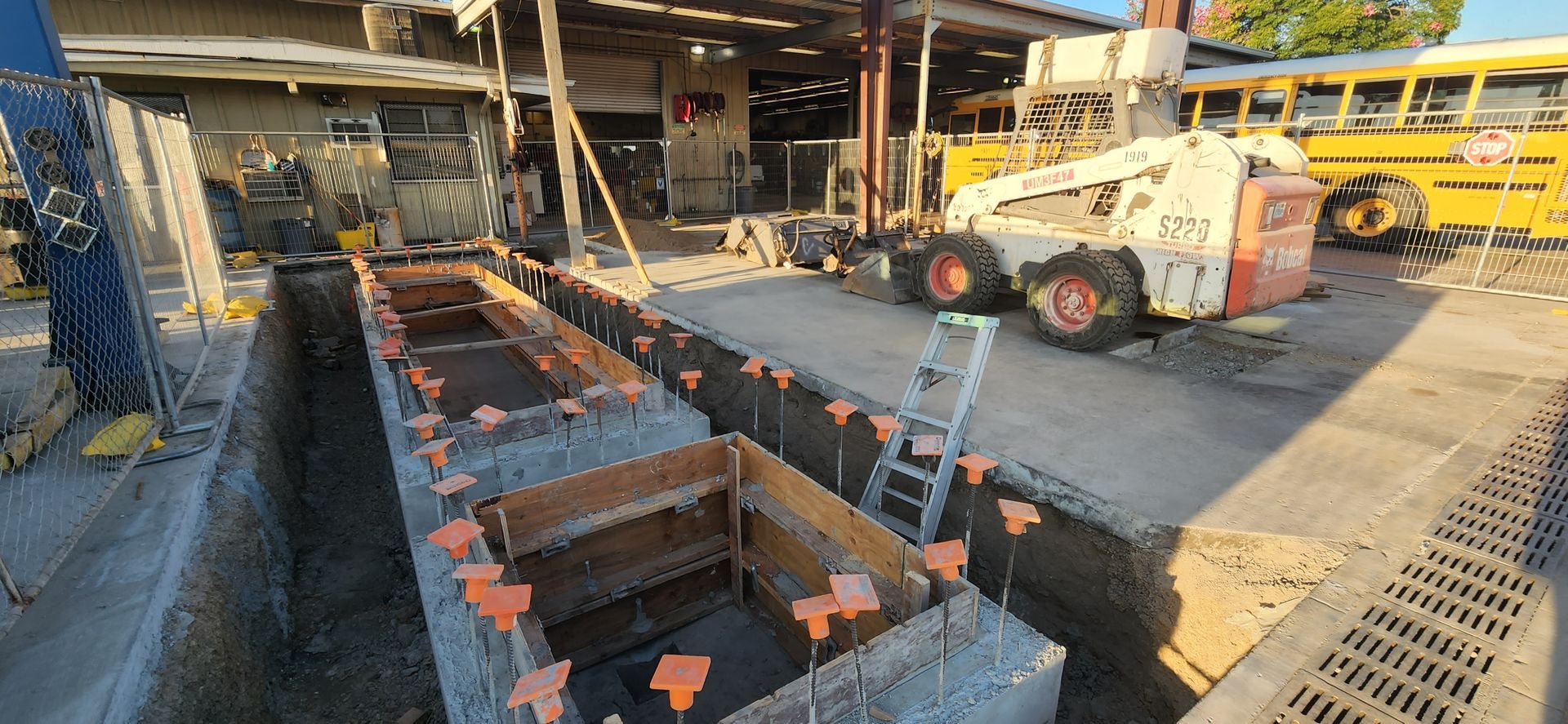 A construction site with a school bus in the background.