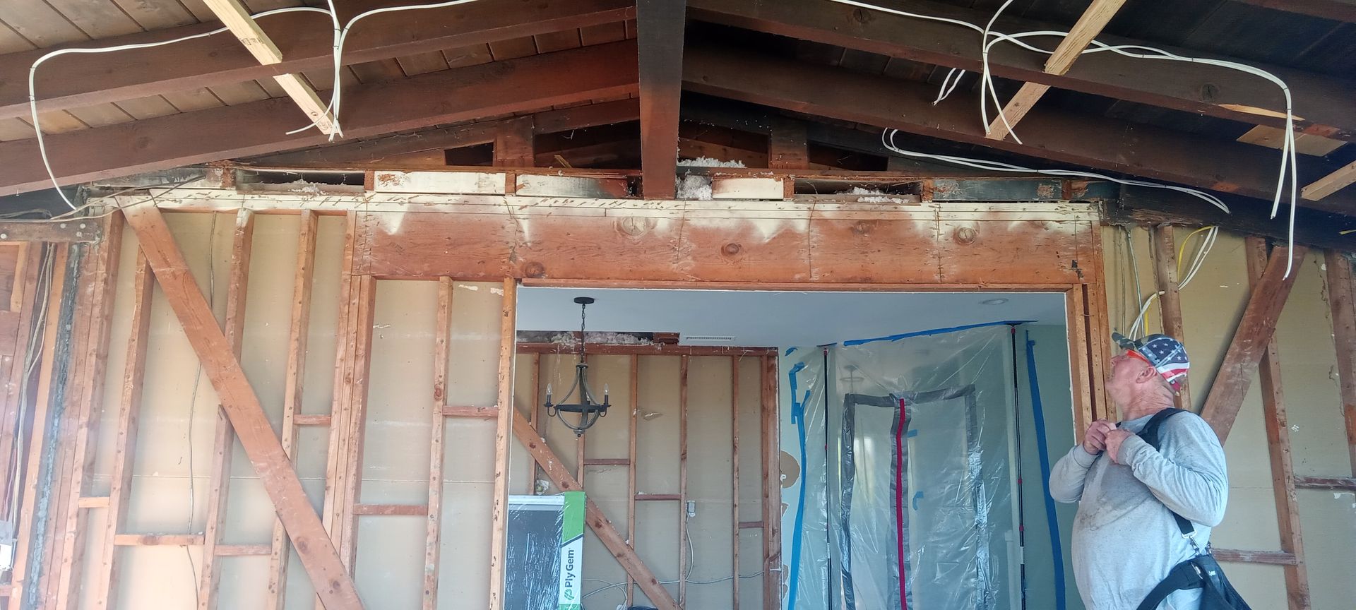 A man is standing in a room that is being remodeled.