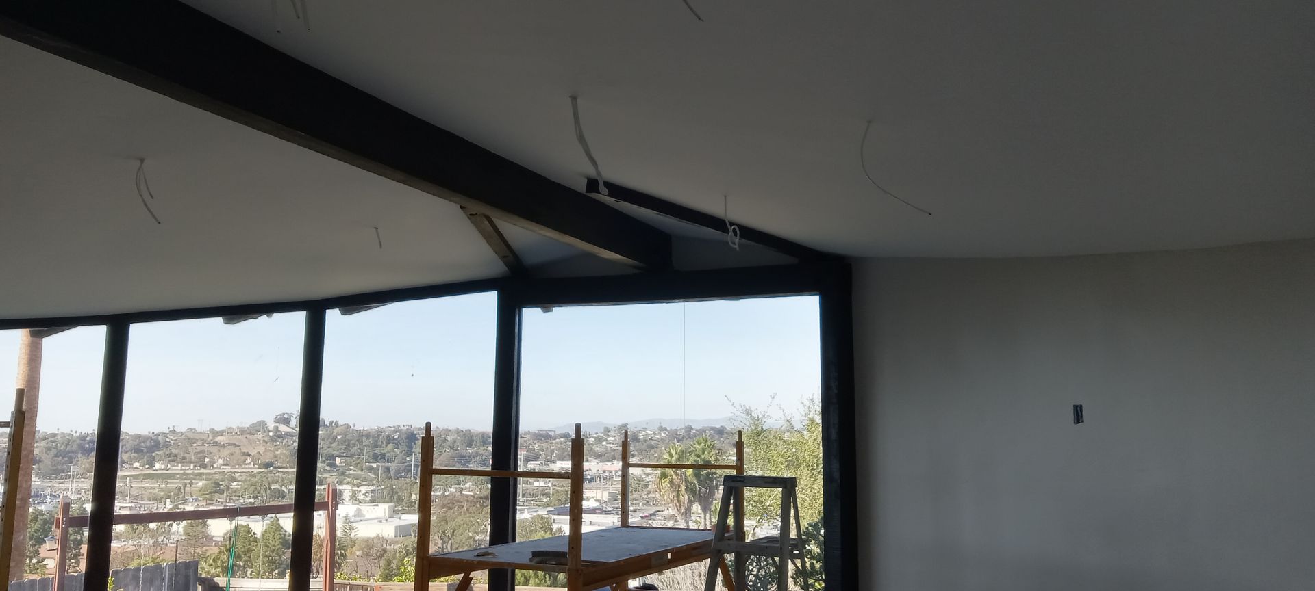A room with a lot of windows and a view of a city.