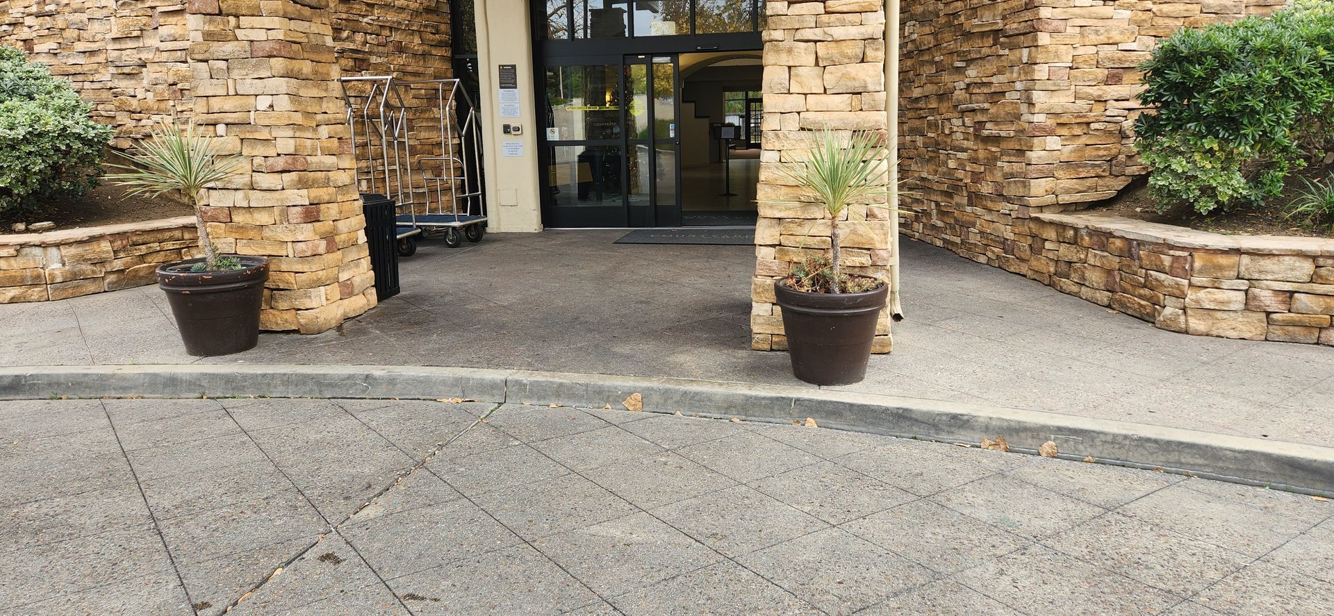 The entrance to a building with potted plants in front of it.