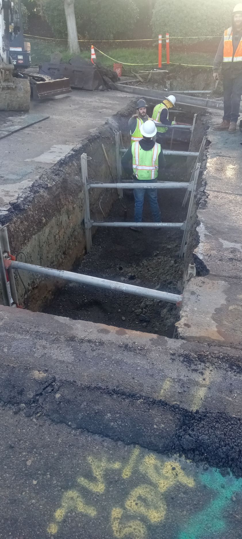 A group of construction workers are digging a hole in the ground.
