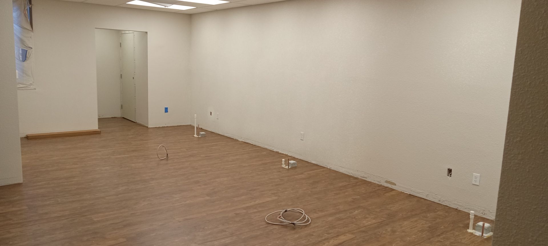 An empty room with hardwood floors and white walls.