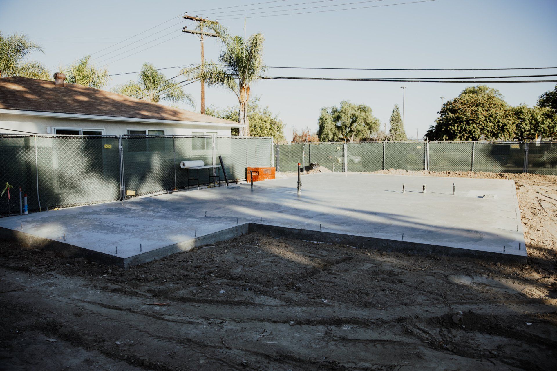 A concrete foundation is being built in front of a house.