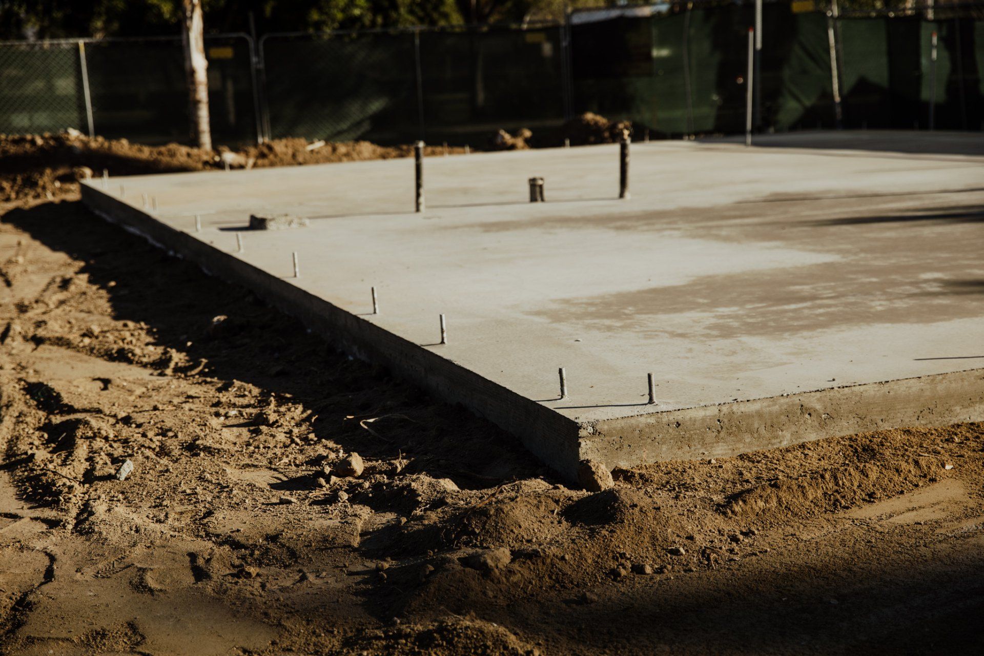 A concrete slab with a fence in the background