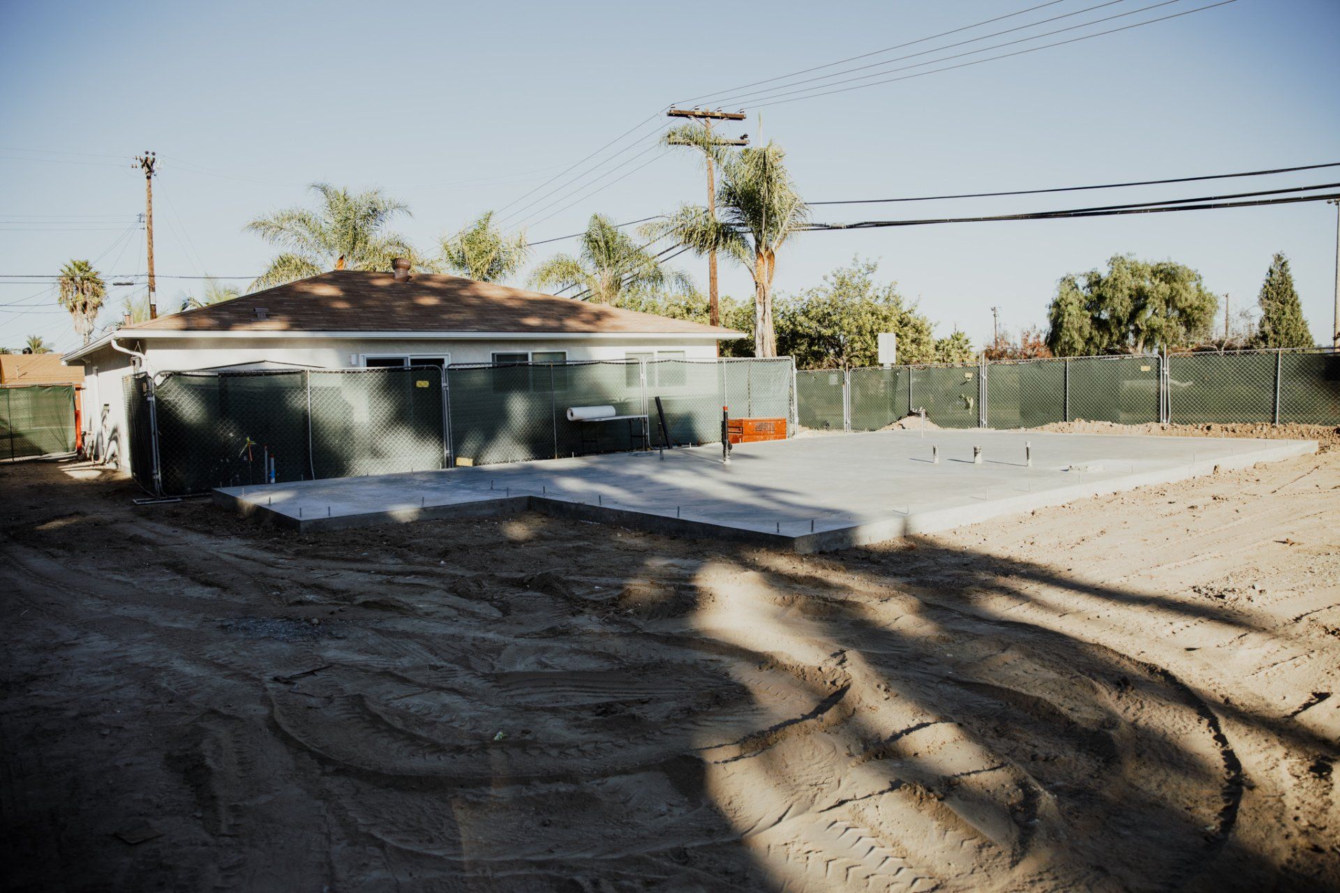 A house is sitting in the middle of a dirt field.