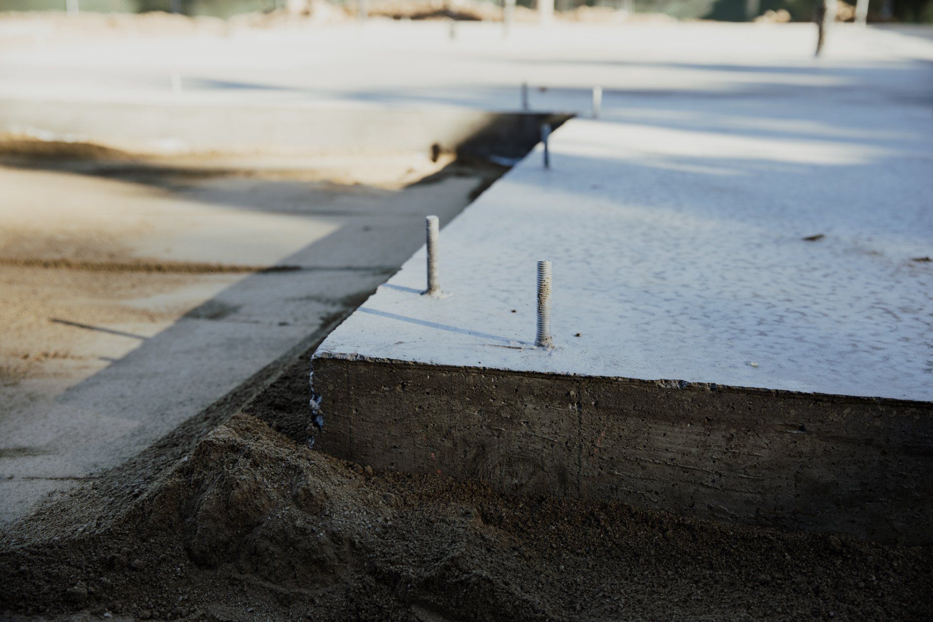 A close up of a concrete slab with nails in it.