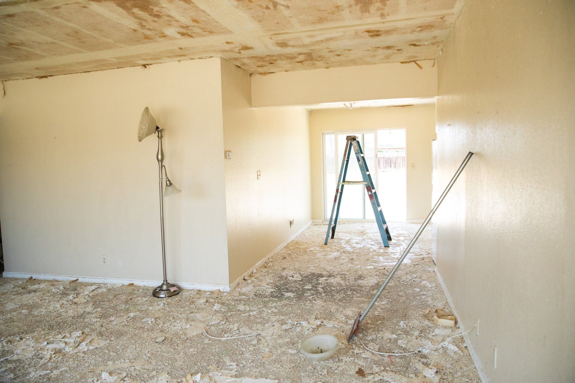 An empty room with a ladder and a lamp