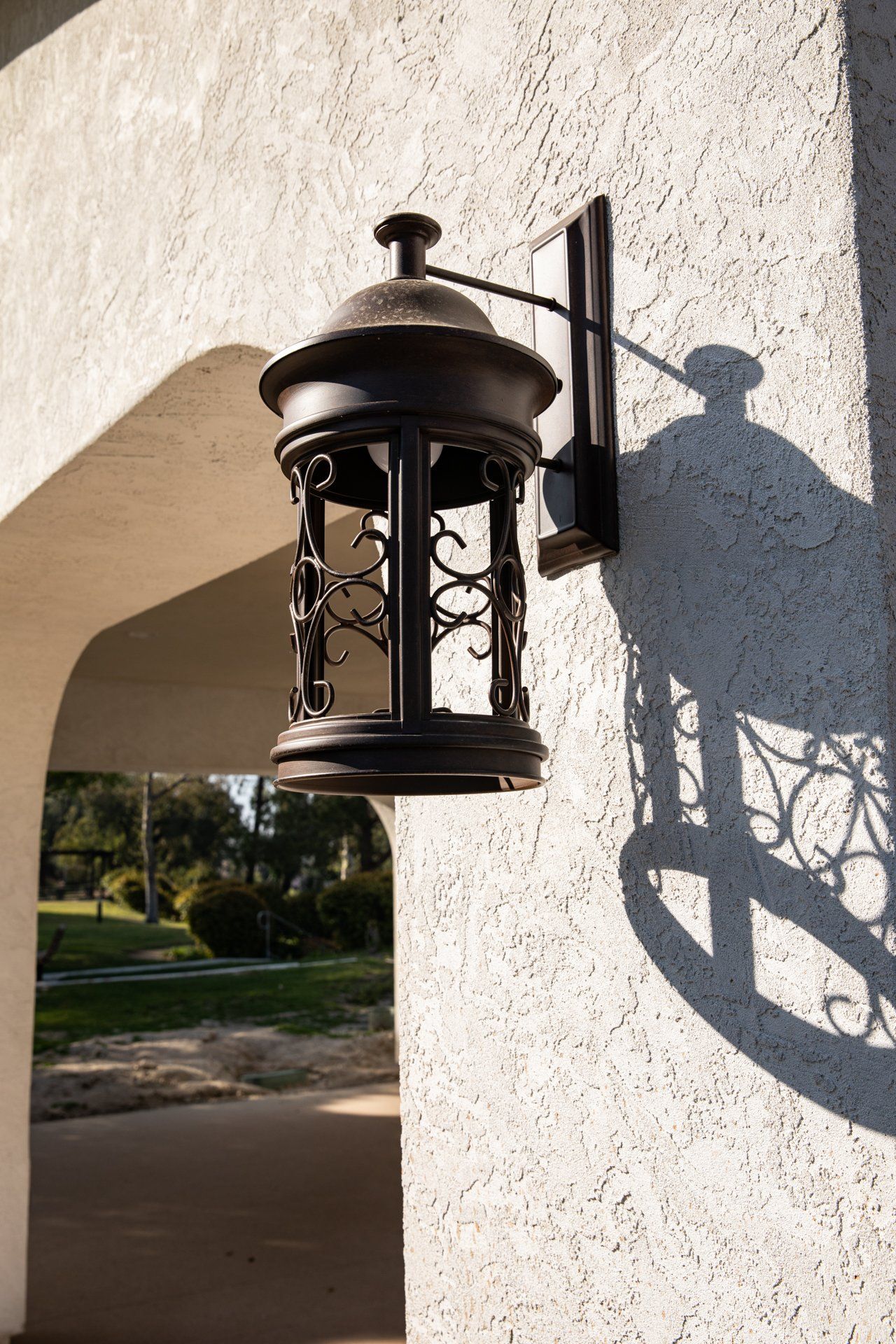 A black lantern is hanging on a white wall.