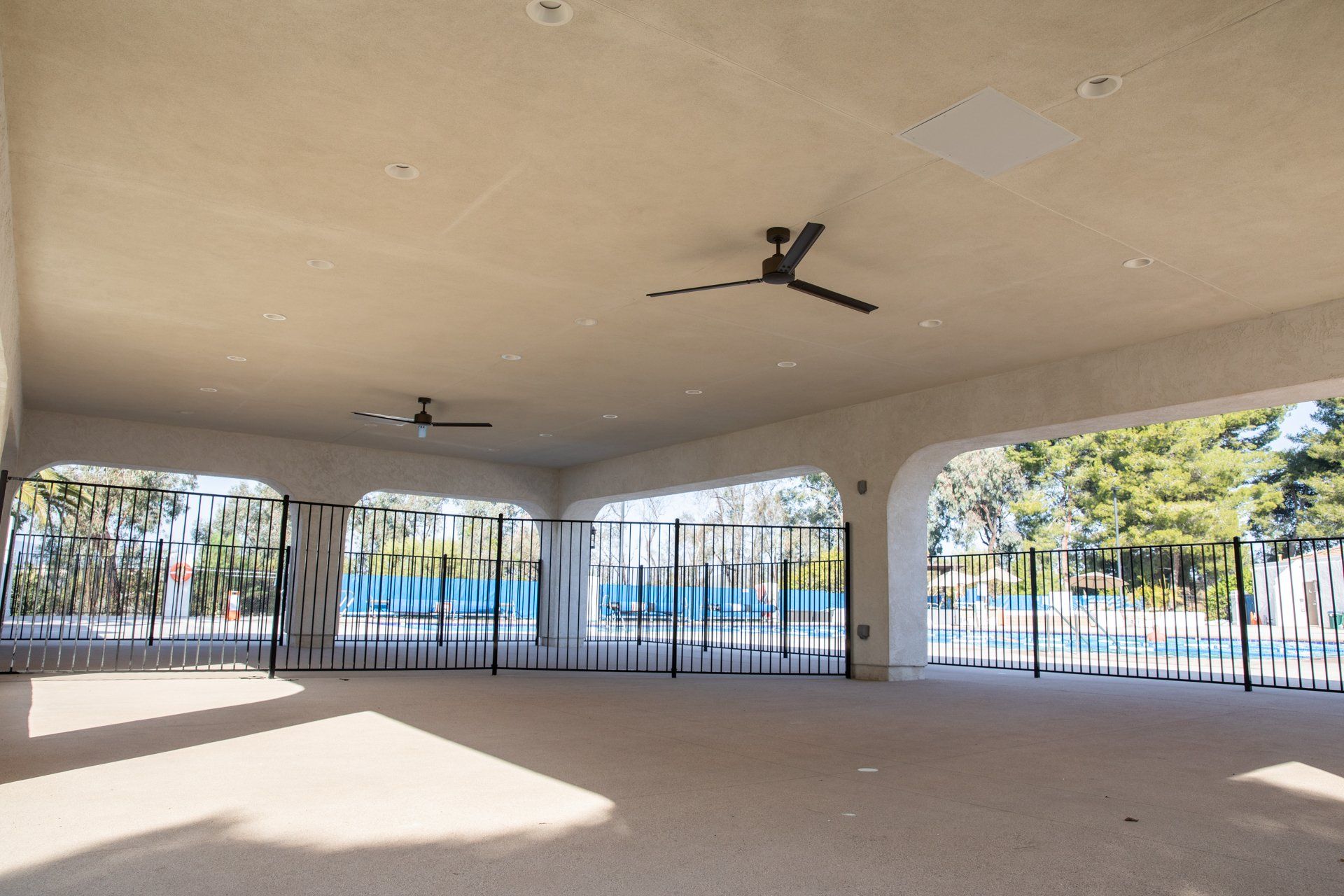 An empty room with a ceiling fan and a fence