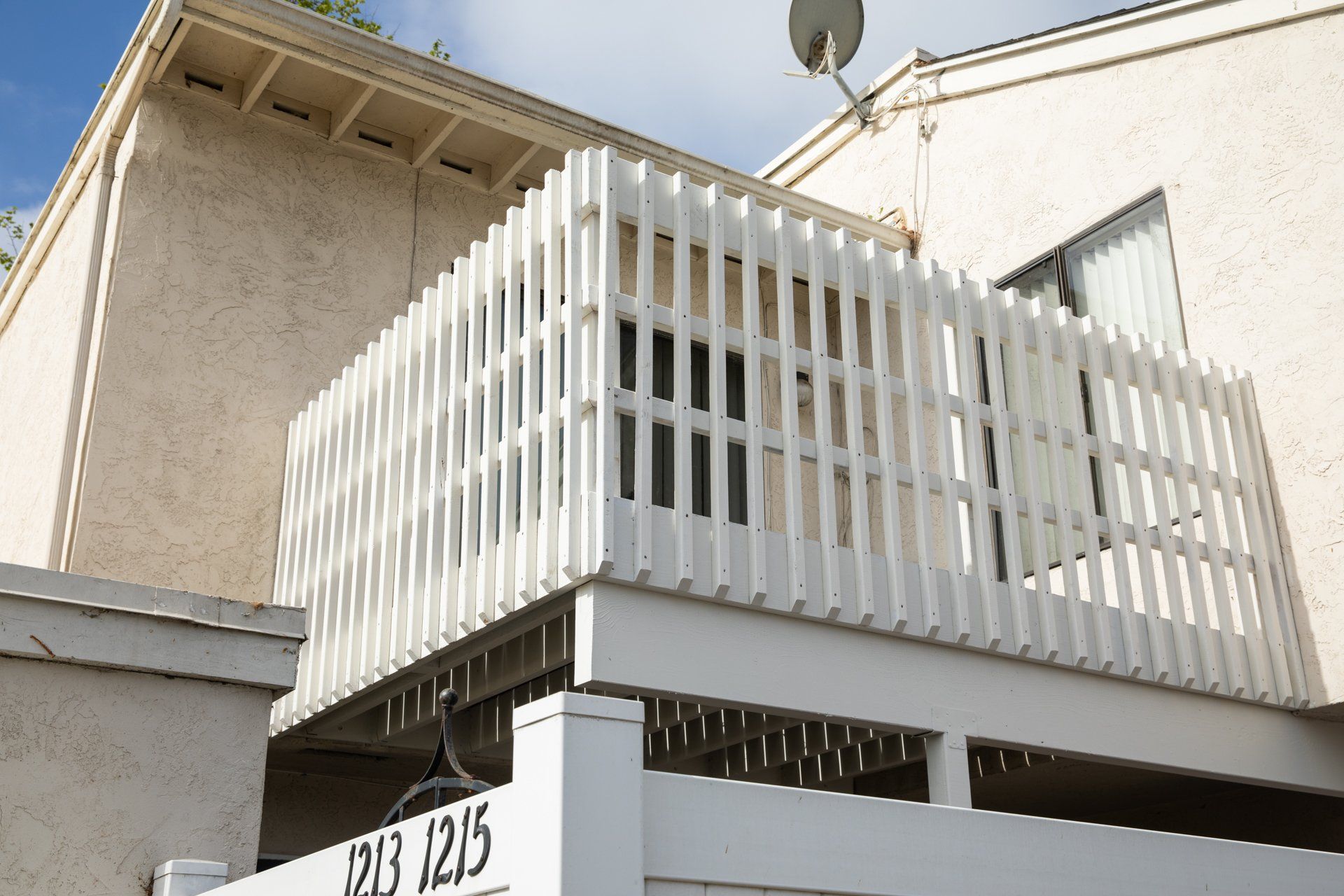 A white fence with the number 323 1215 on it