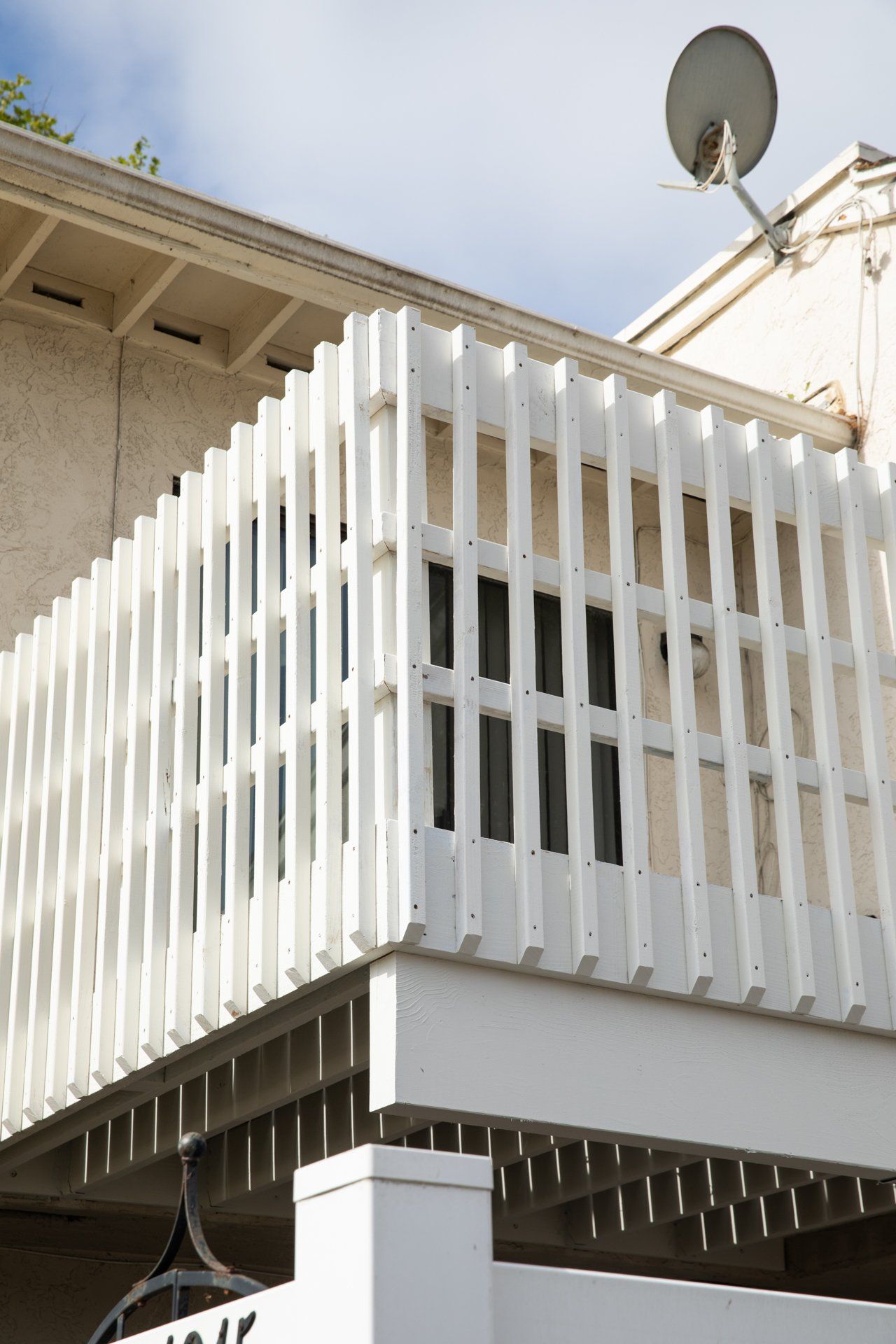 A white fence with a satellite dish on top of it
