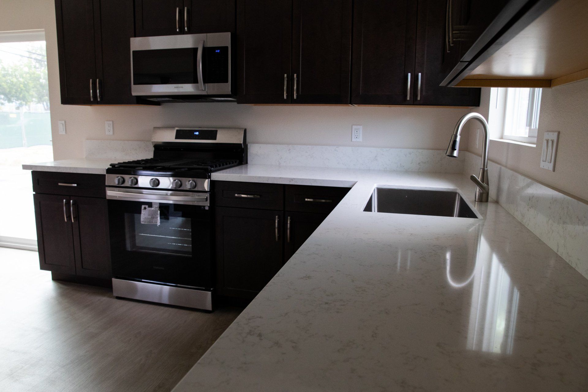A kitchen with a stove a sink and a microwave