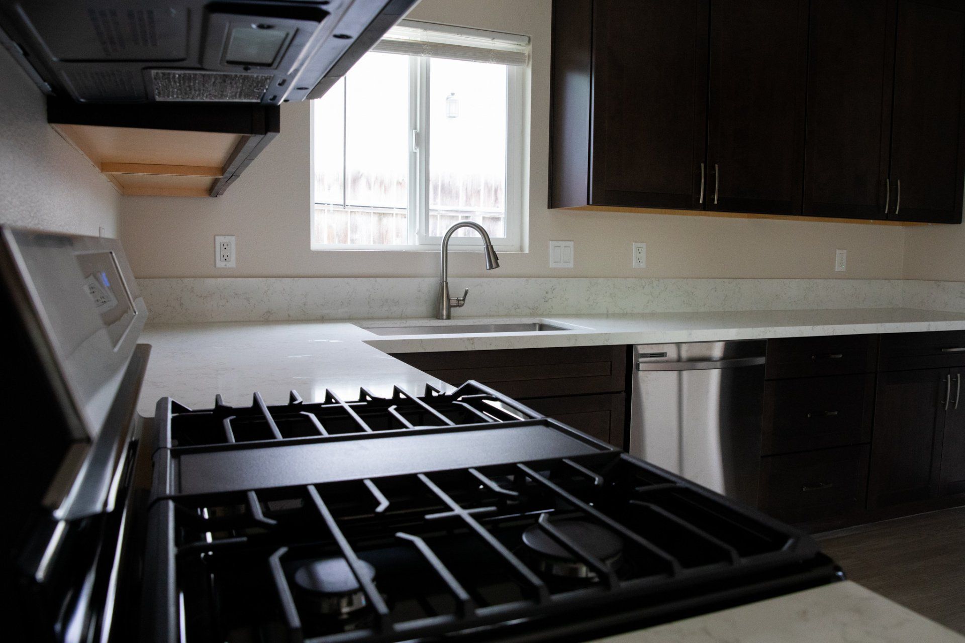A kitchen with a stove top oven and a sink