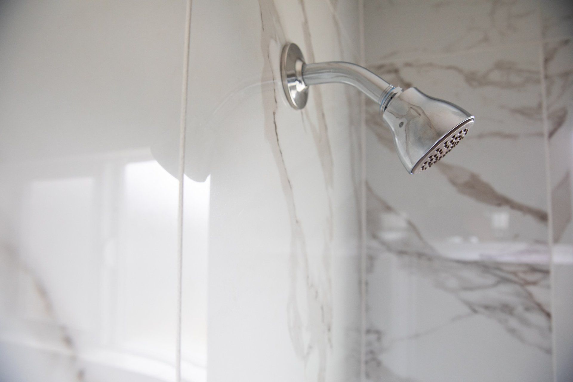 A close up of a shower head in a bathroom.