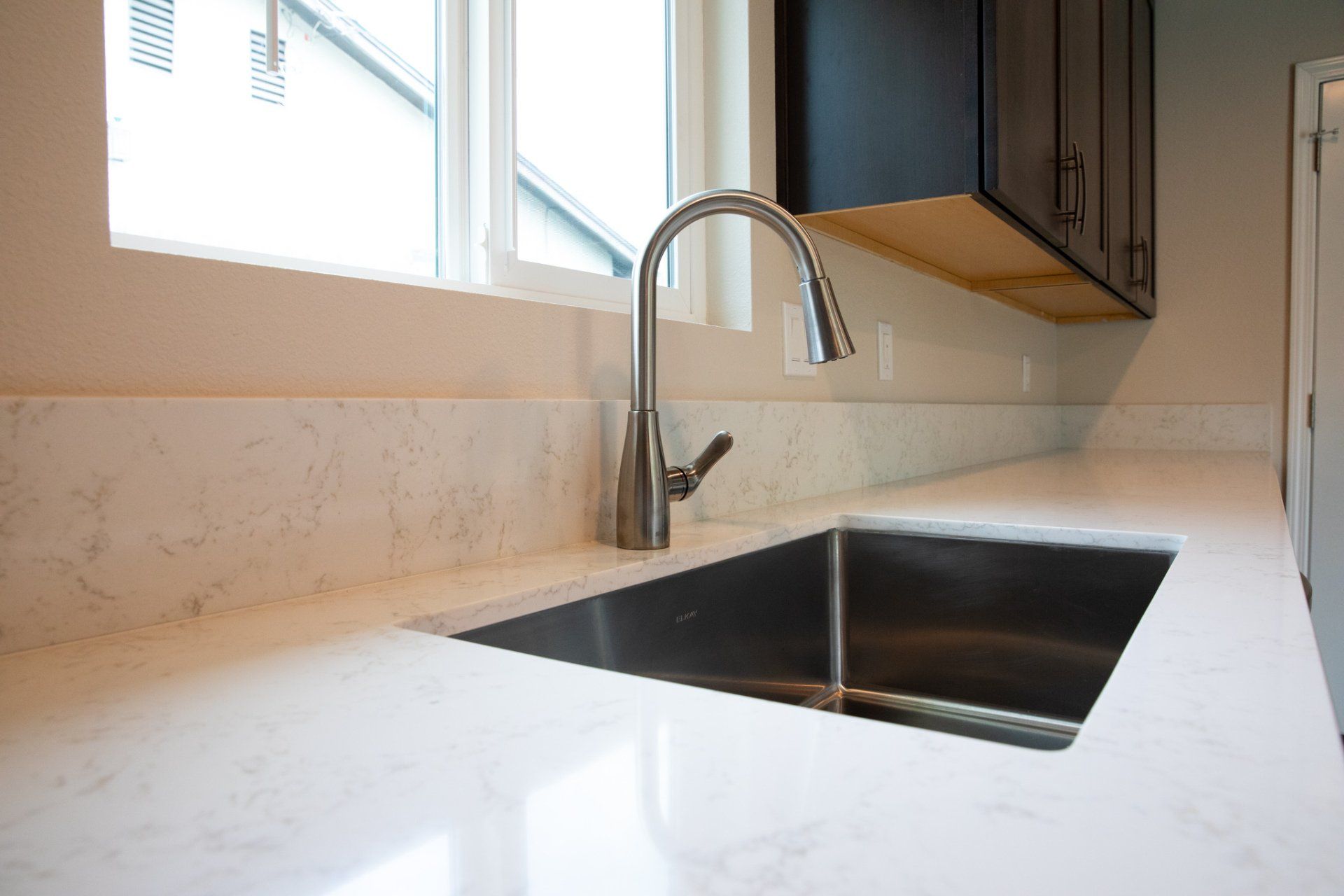 A kitchen with a stainless steel sink and a window