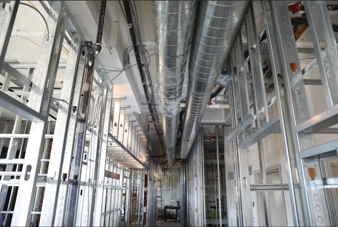 Industrial interior with exposed metal ducts, beams, and framing in a construction site