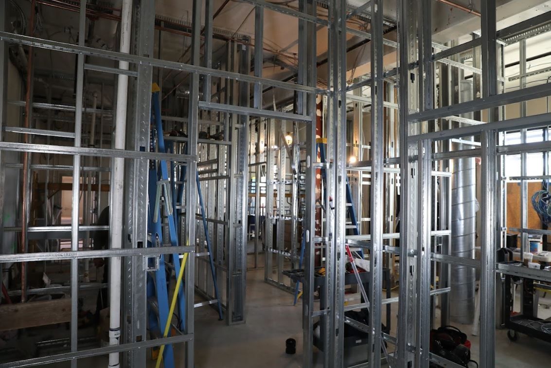 Interior construction site with metal wall framing and exposed studs in a partially built room