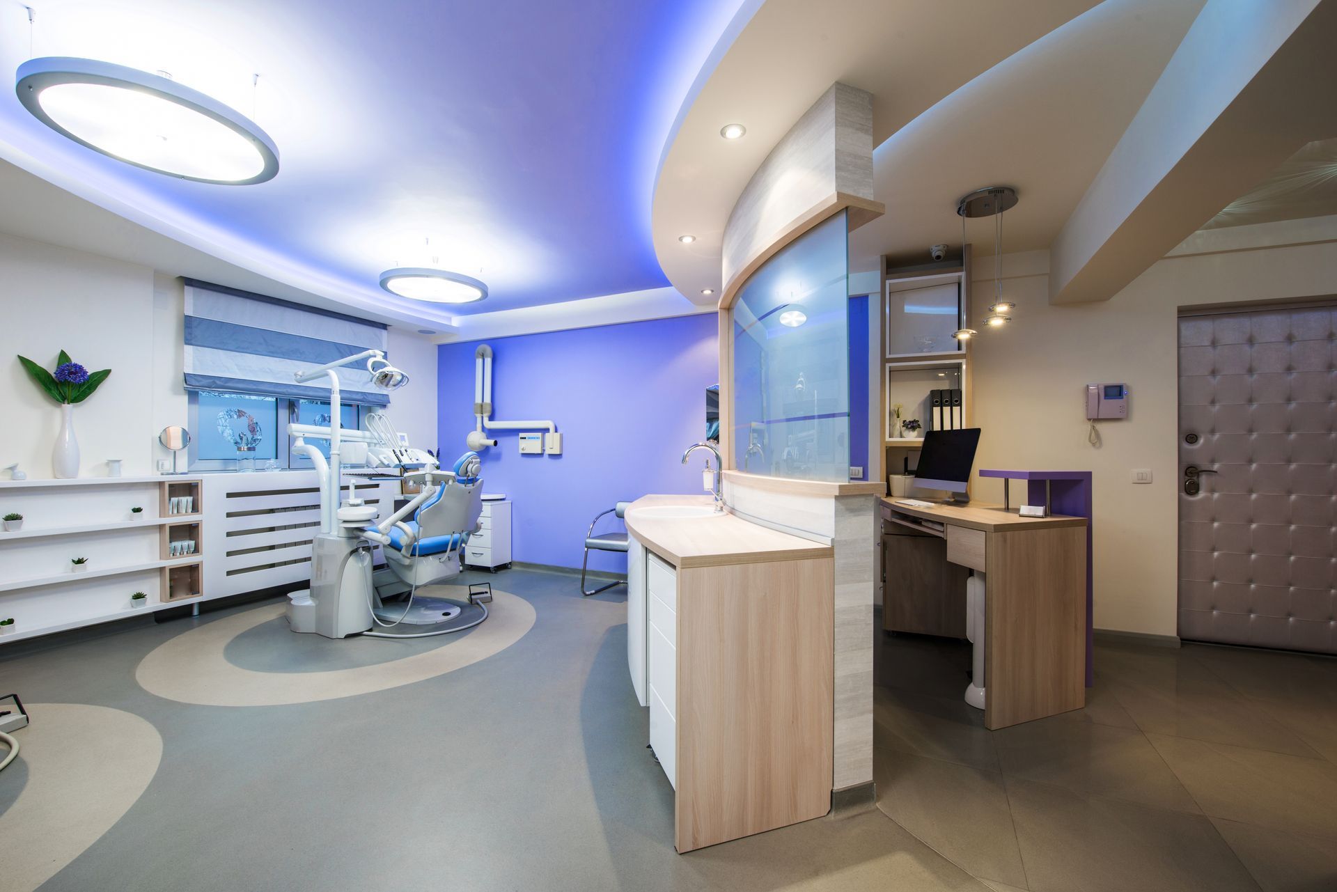 A dental office with a dental chair and a desk.