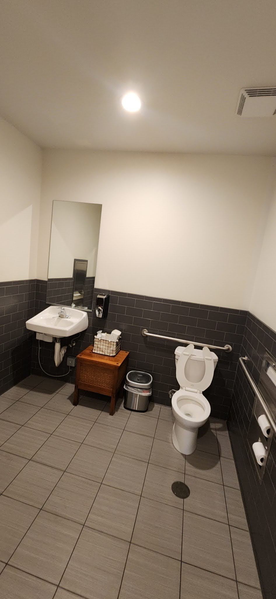 A bathroom with a toilet , sink and mirror