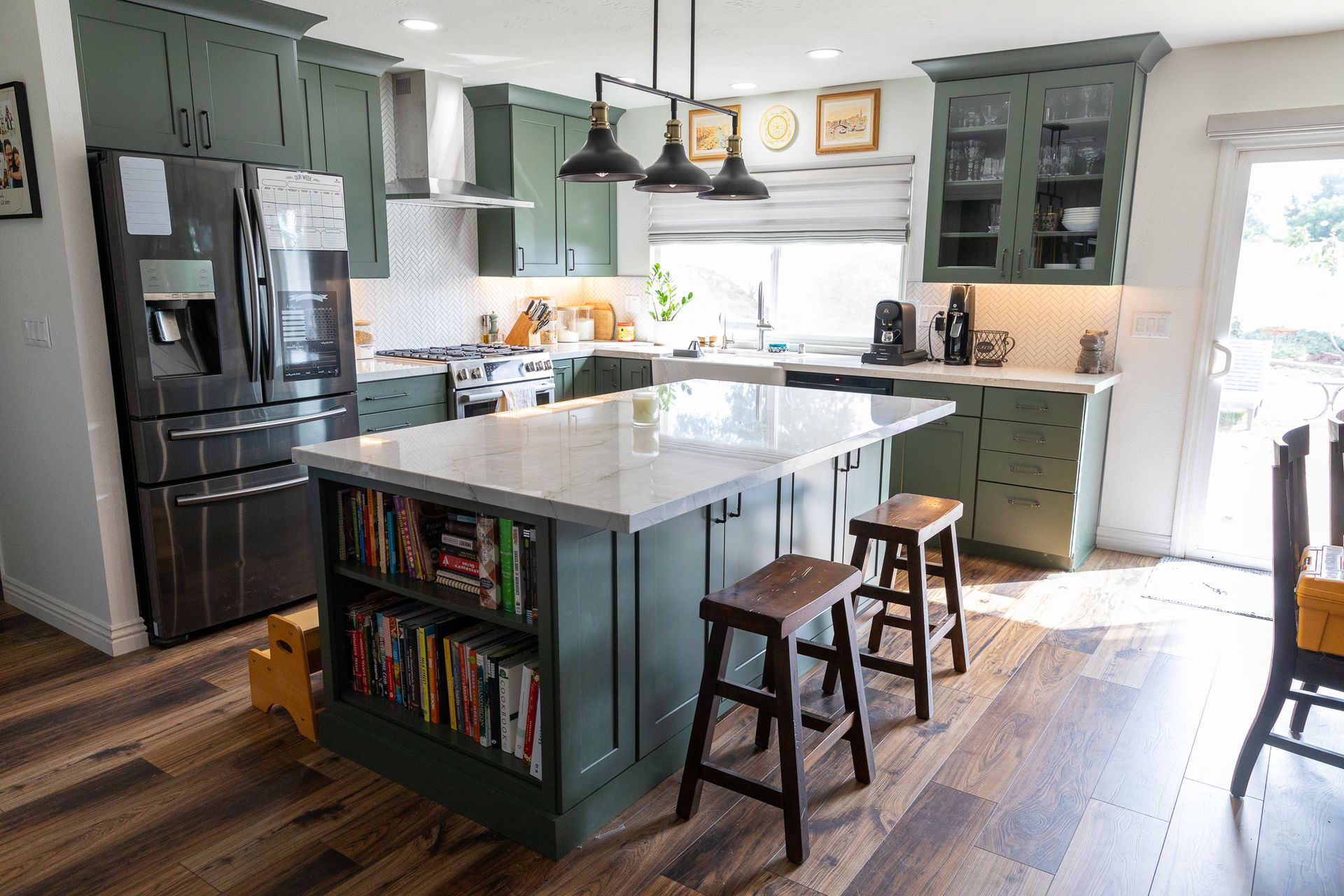 A kitchen with green cabinets and white counter tops