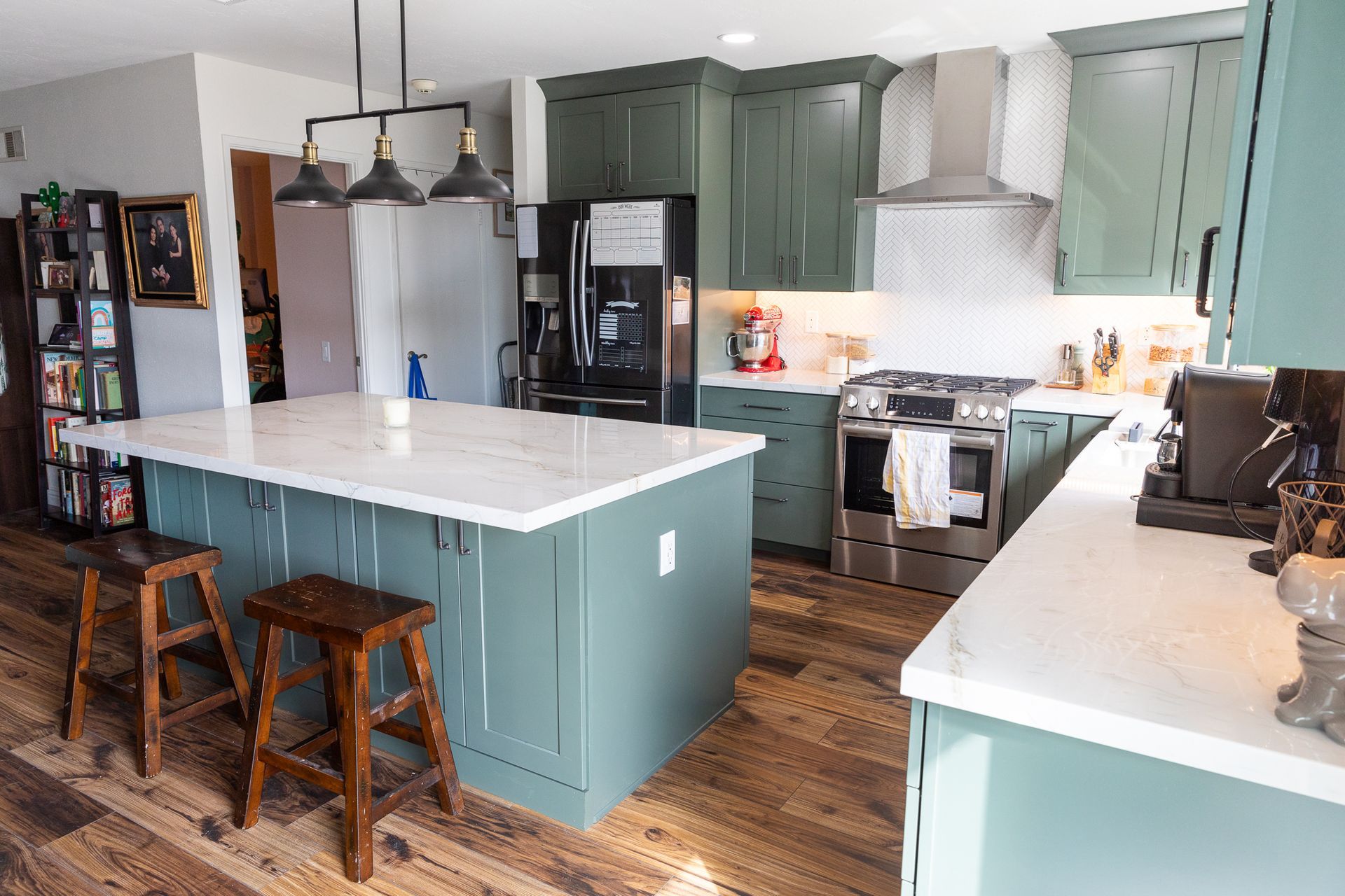 A kitchen with green cabinets and white counter tops