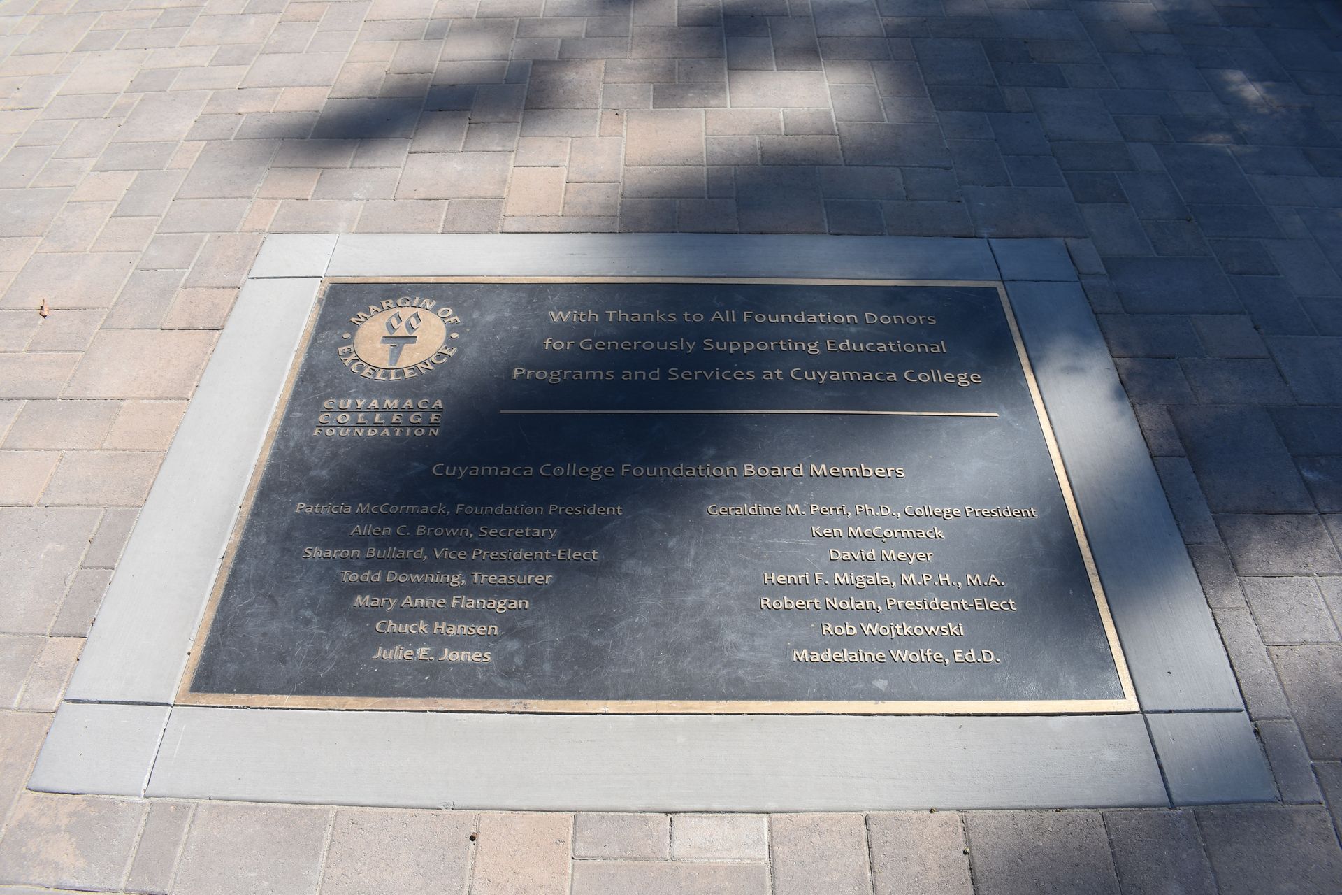 A plaque on a sidewalk that says ' memorial ' on it