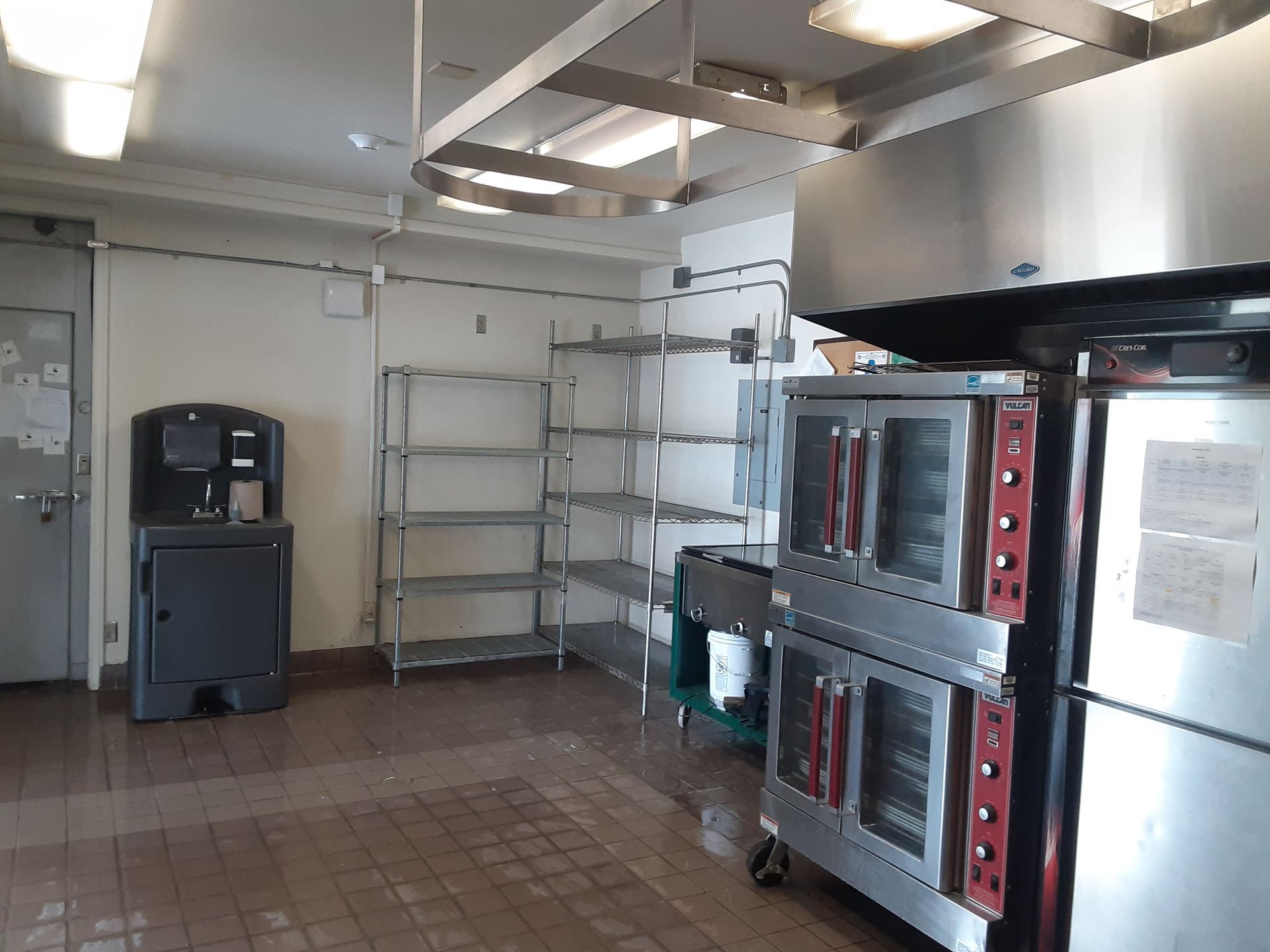 A kitchen with stainless steel appliances and shelves