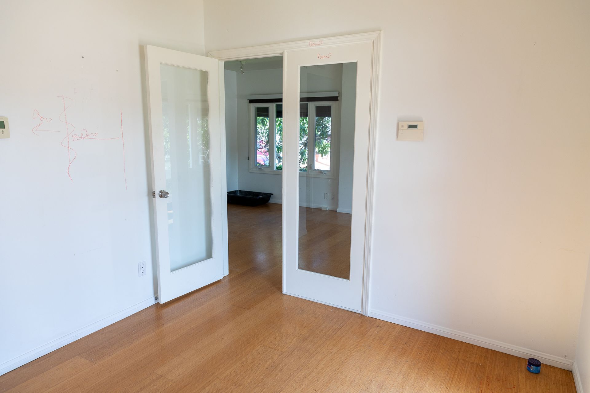 An empty room with hardwood floors and white walls.