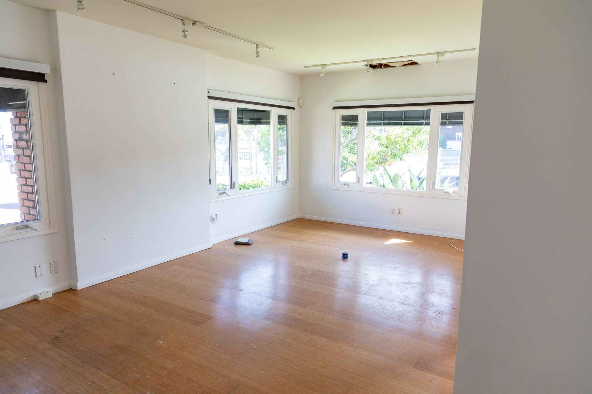 An empty room with a wooden floor and white walls