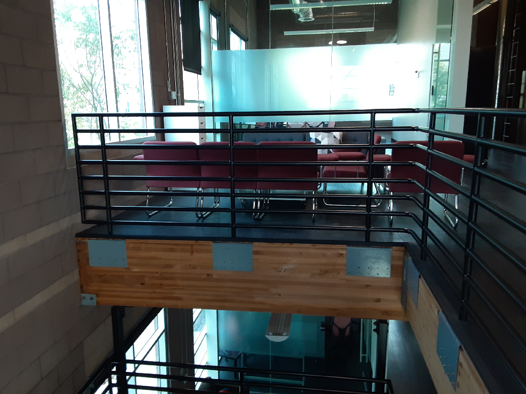 A staircase with a metal railing and a wooden platform