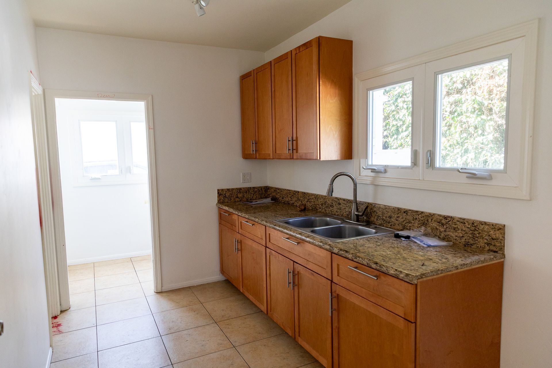 An empty kitchen with wooden cabinets and granite counter tops