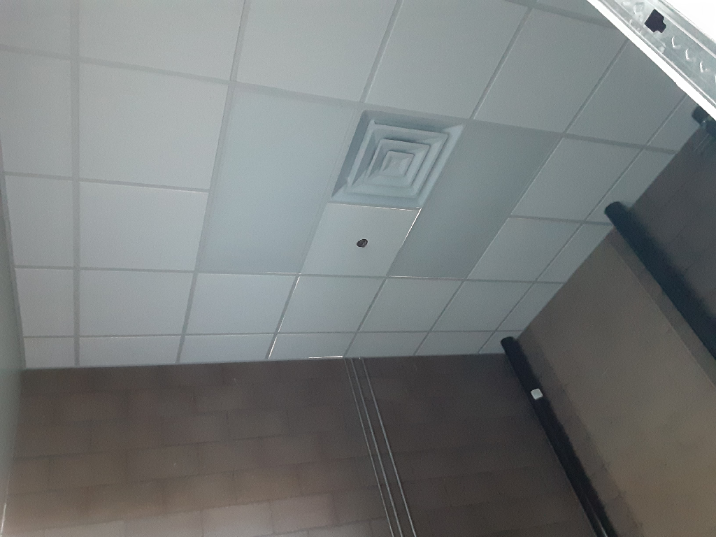 A room with a ceiling that has square tiles on it