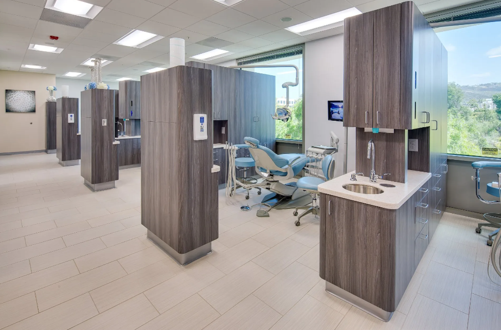 A dental office with a lot of cabinets and a dental chair.