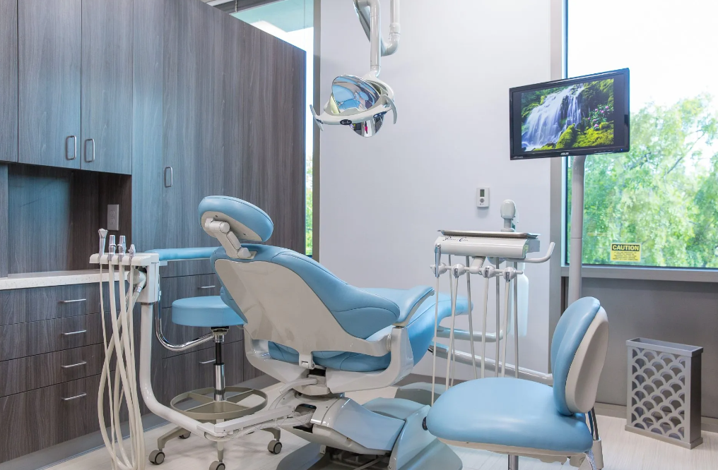 A dental office with a dental chair and a television.