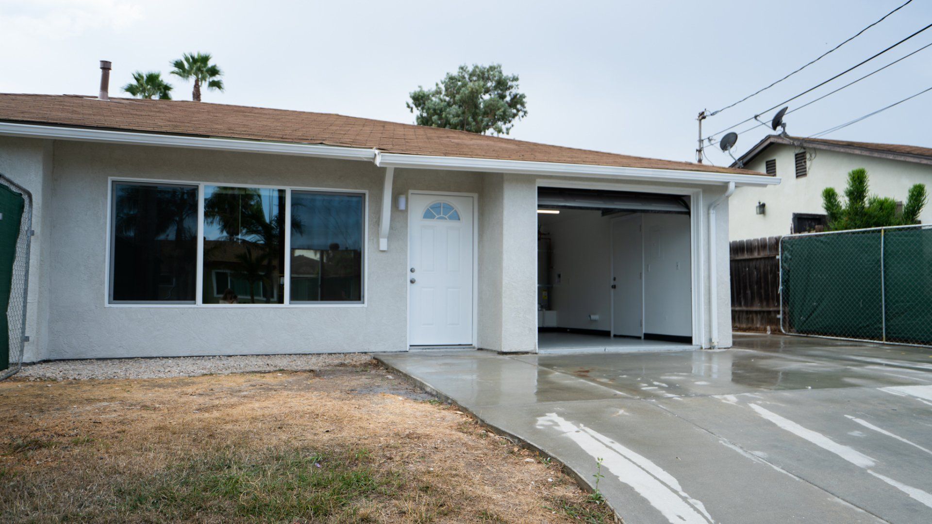 A house with a garage and a fence in front of it
