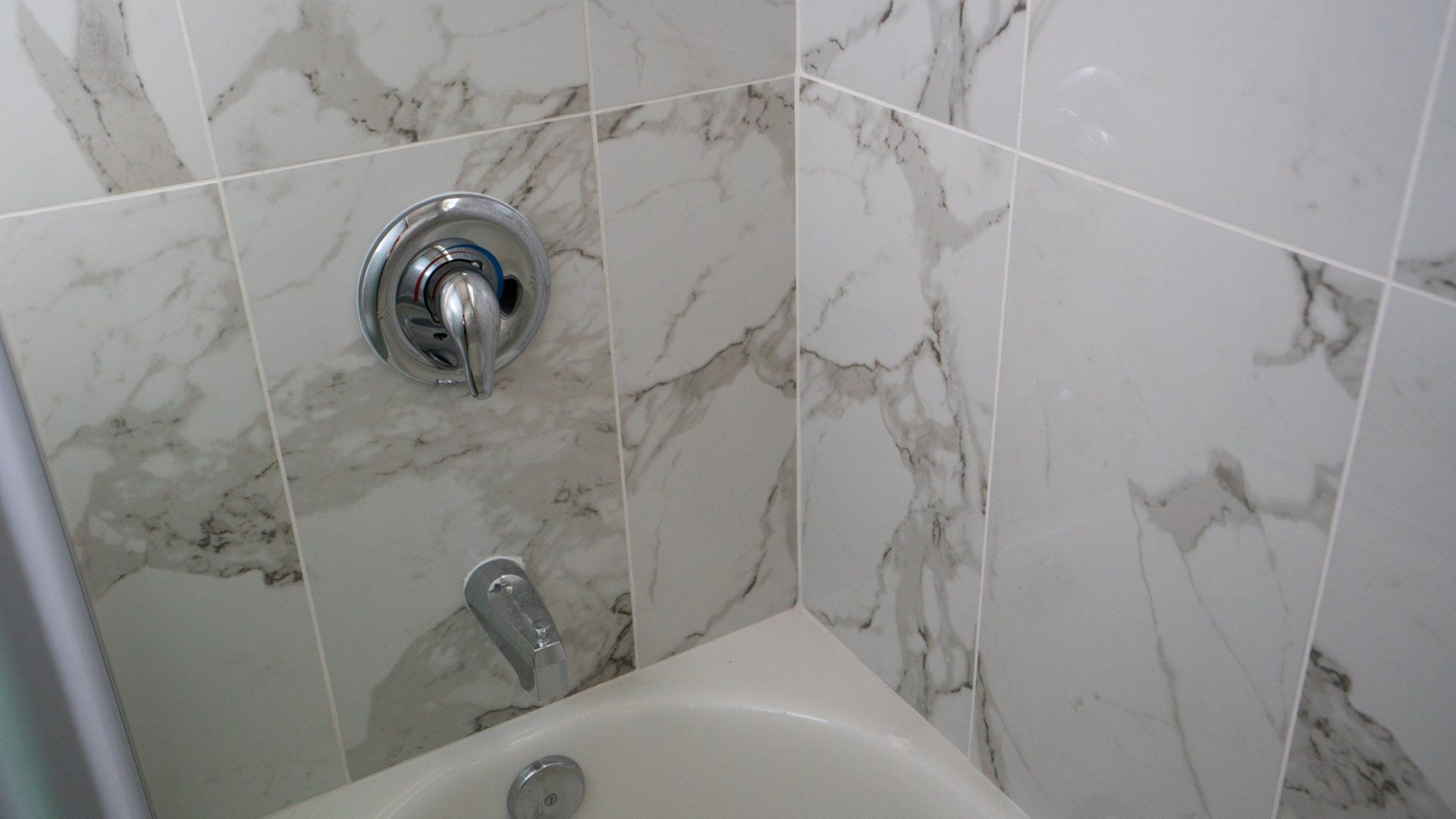 A bathroom with marble tiles and a bathtub
